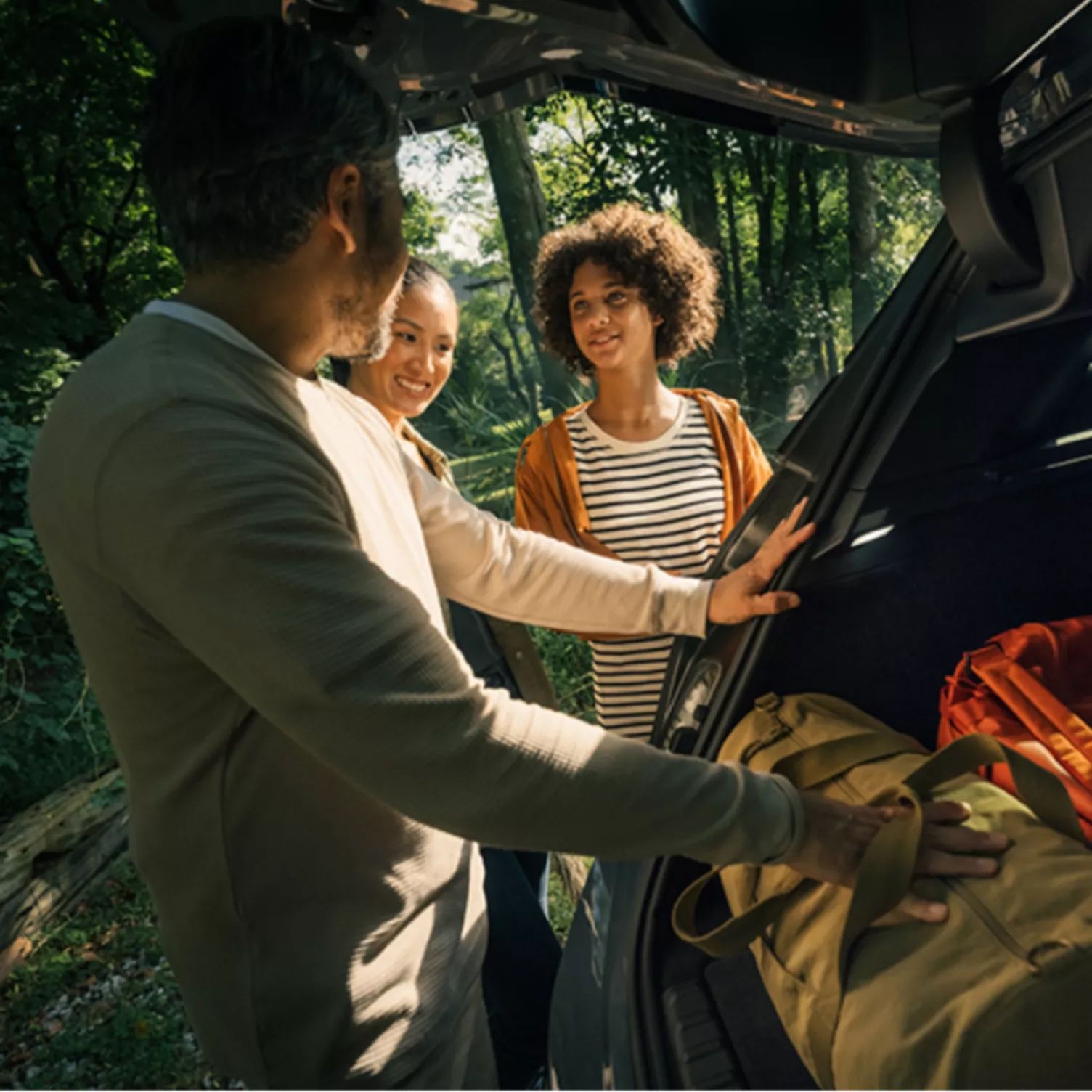 A family removes items from their BMW tailgate as they get ready to go for a hike