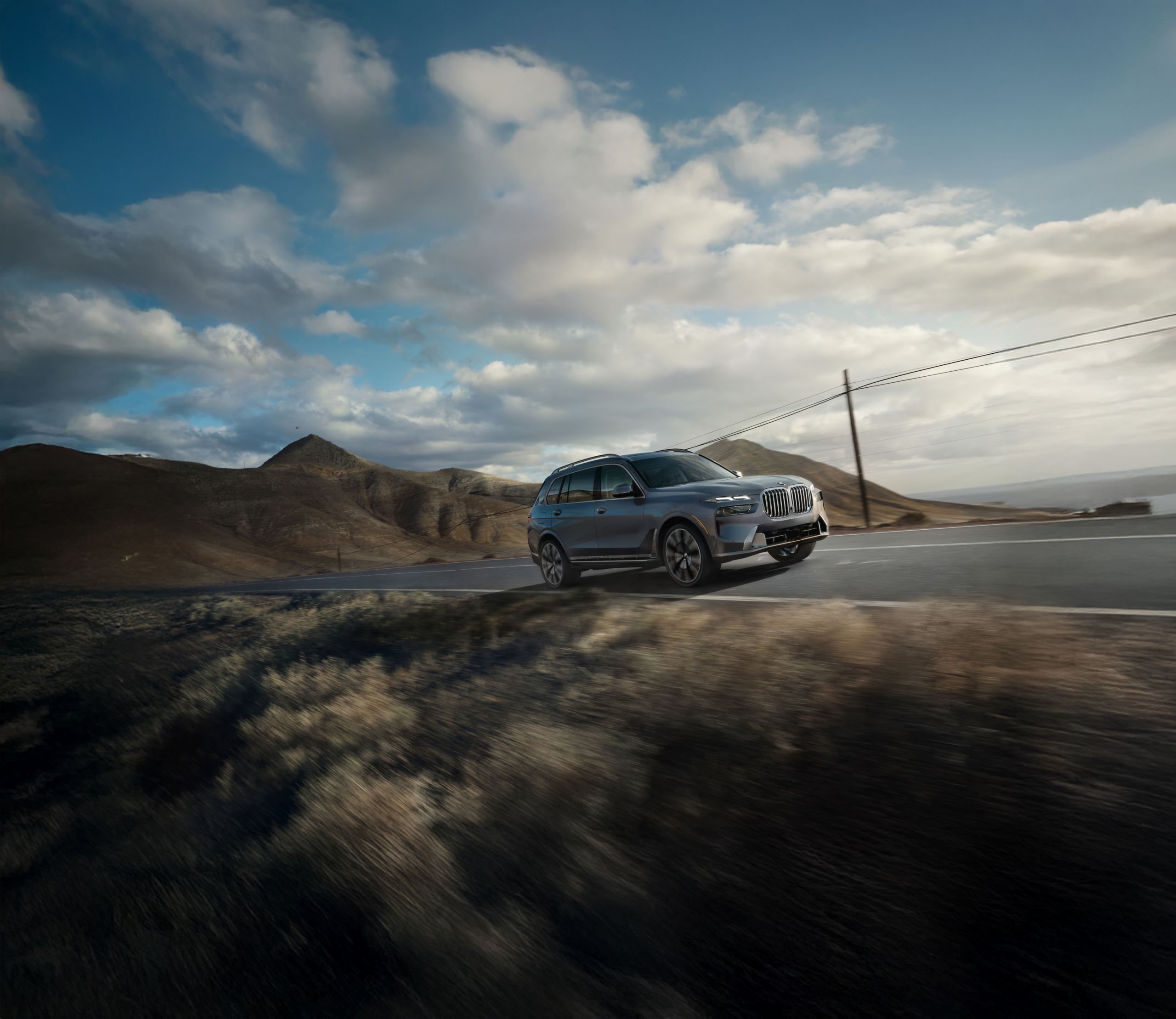 The BMW X7 driving up a scenic mountain highway.