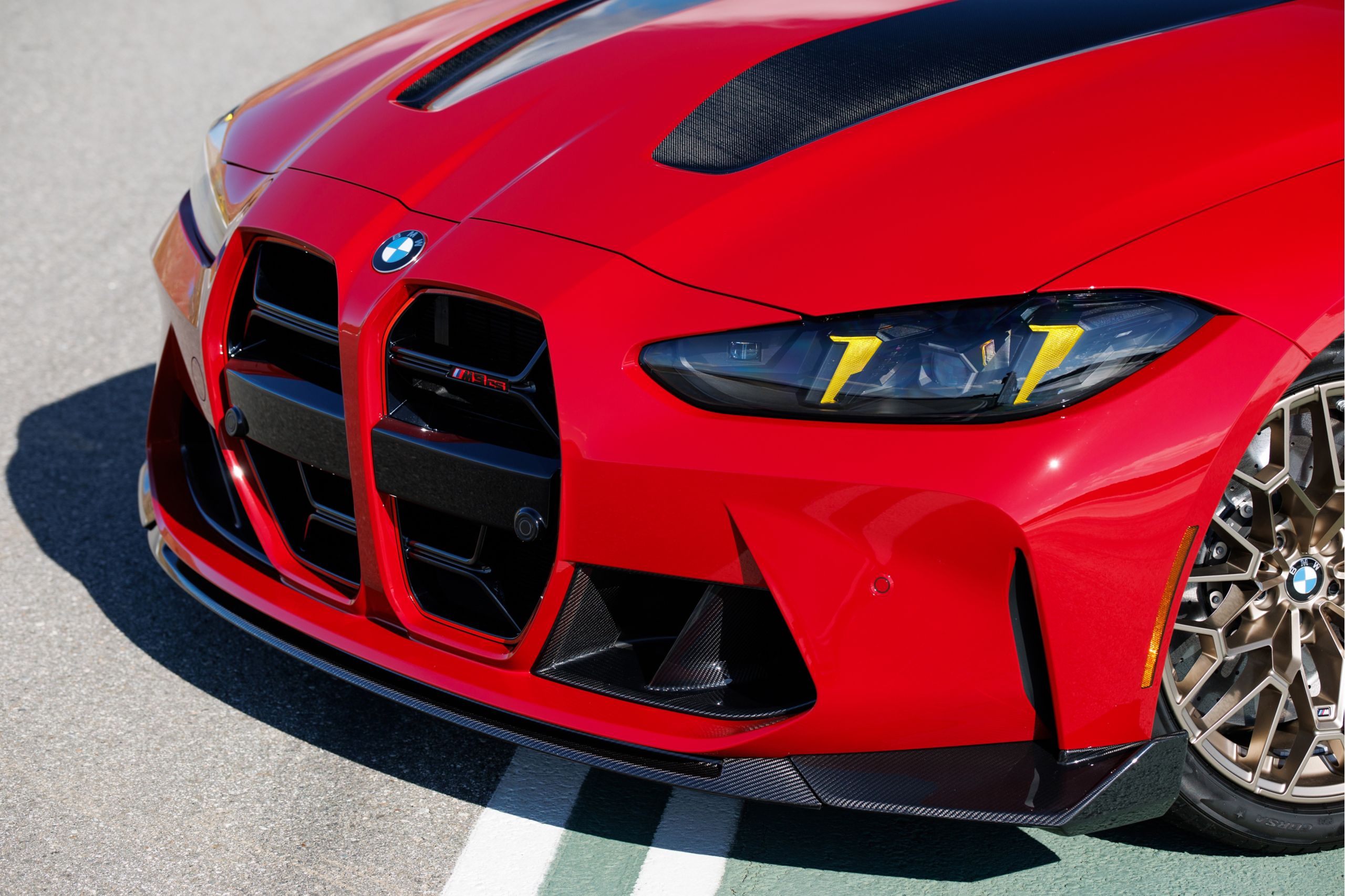 A close-up image showing the exterior of the M3 CS Handschalter's front design, with a dramatic shadow underneath