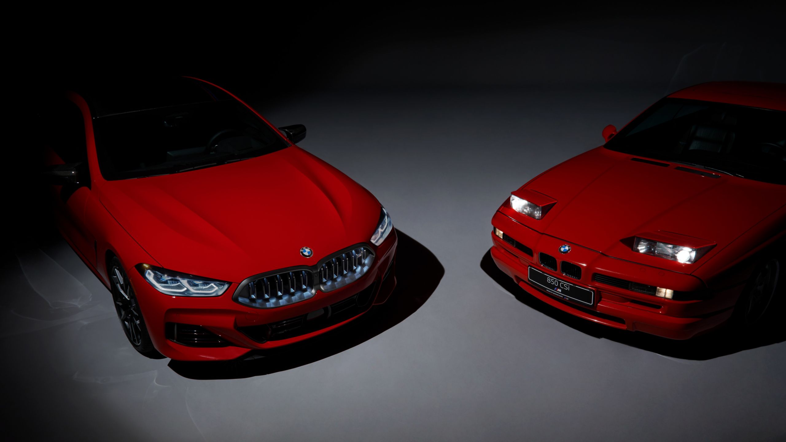 Two M850i Edition M Heritage models, one with the headlights open, once with them closed