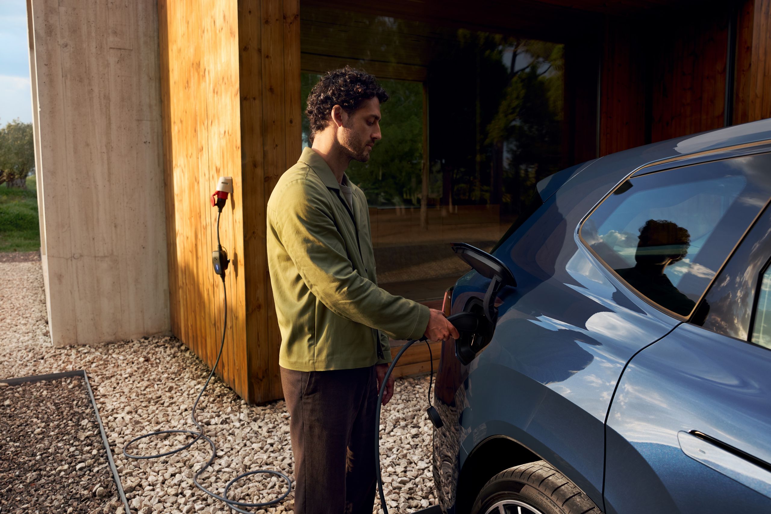 A person is operating the central display in the BMW iX3