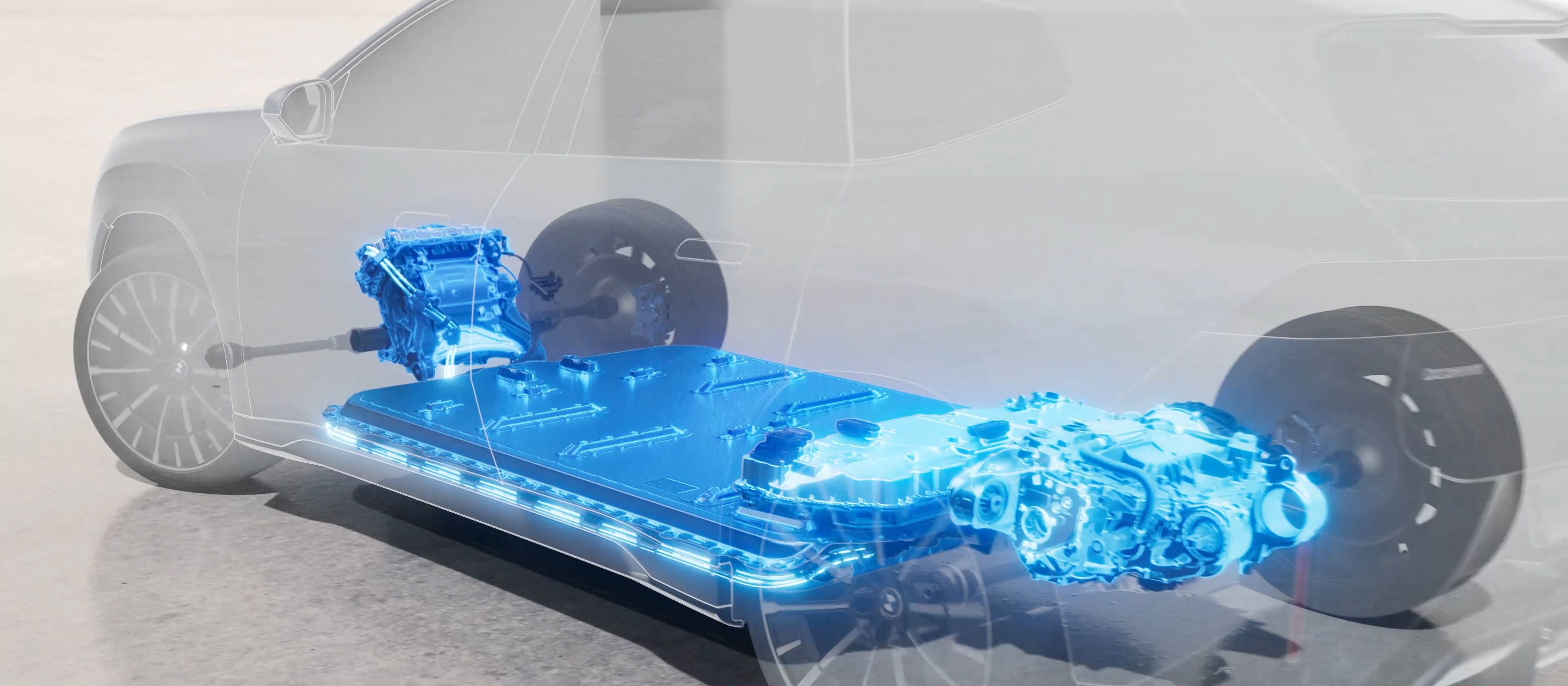 An almost transparent BMW stands in a bright, modern setting, revealing the high-voltage battery in the floor of the vehicle and how the energy is distributed to the front and rear axles