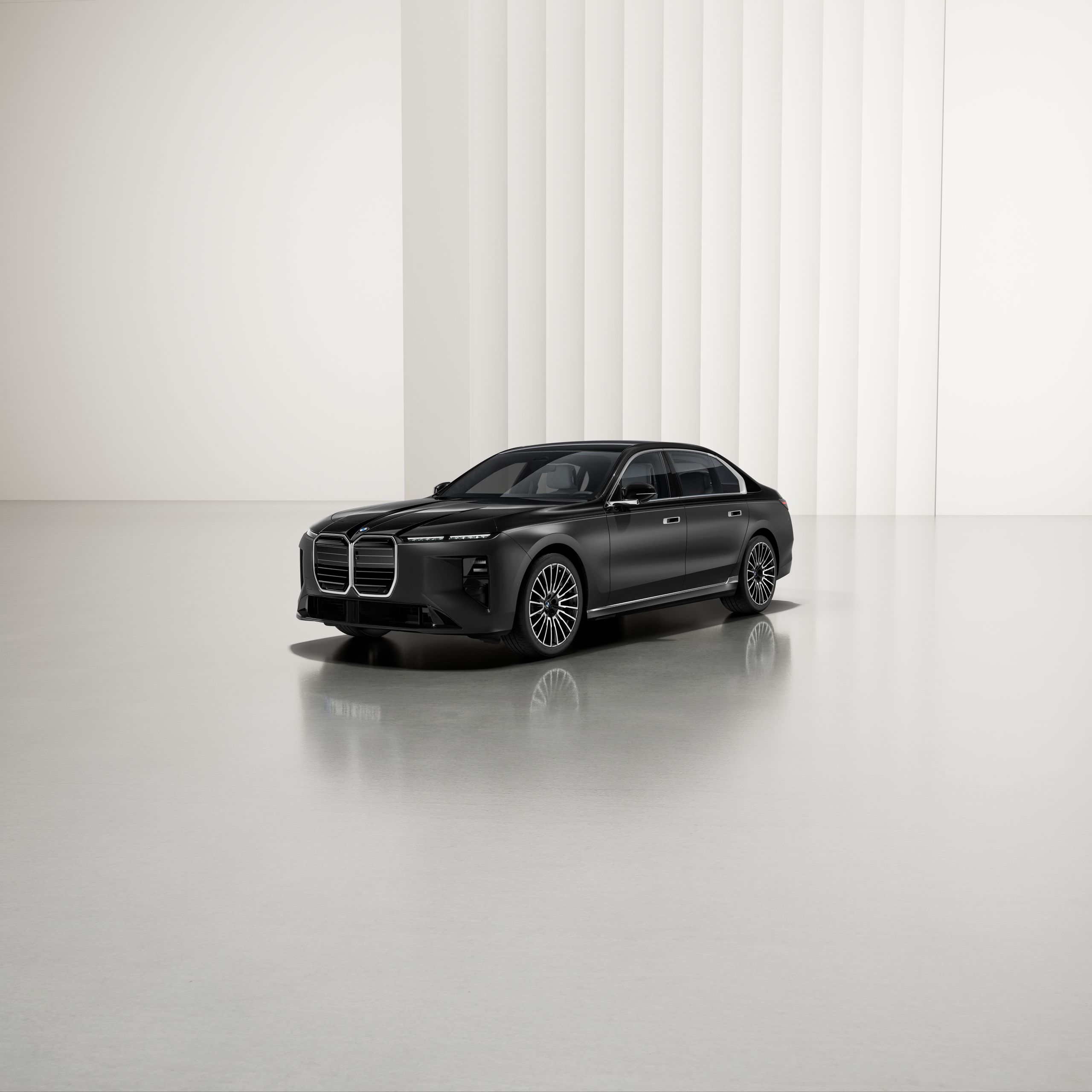 A BMW with two-tone paintwork at an angle on a reflective surface, with a modern background.