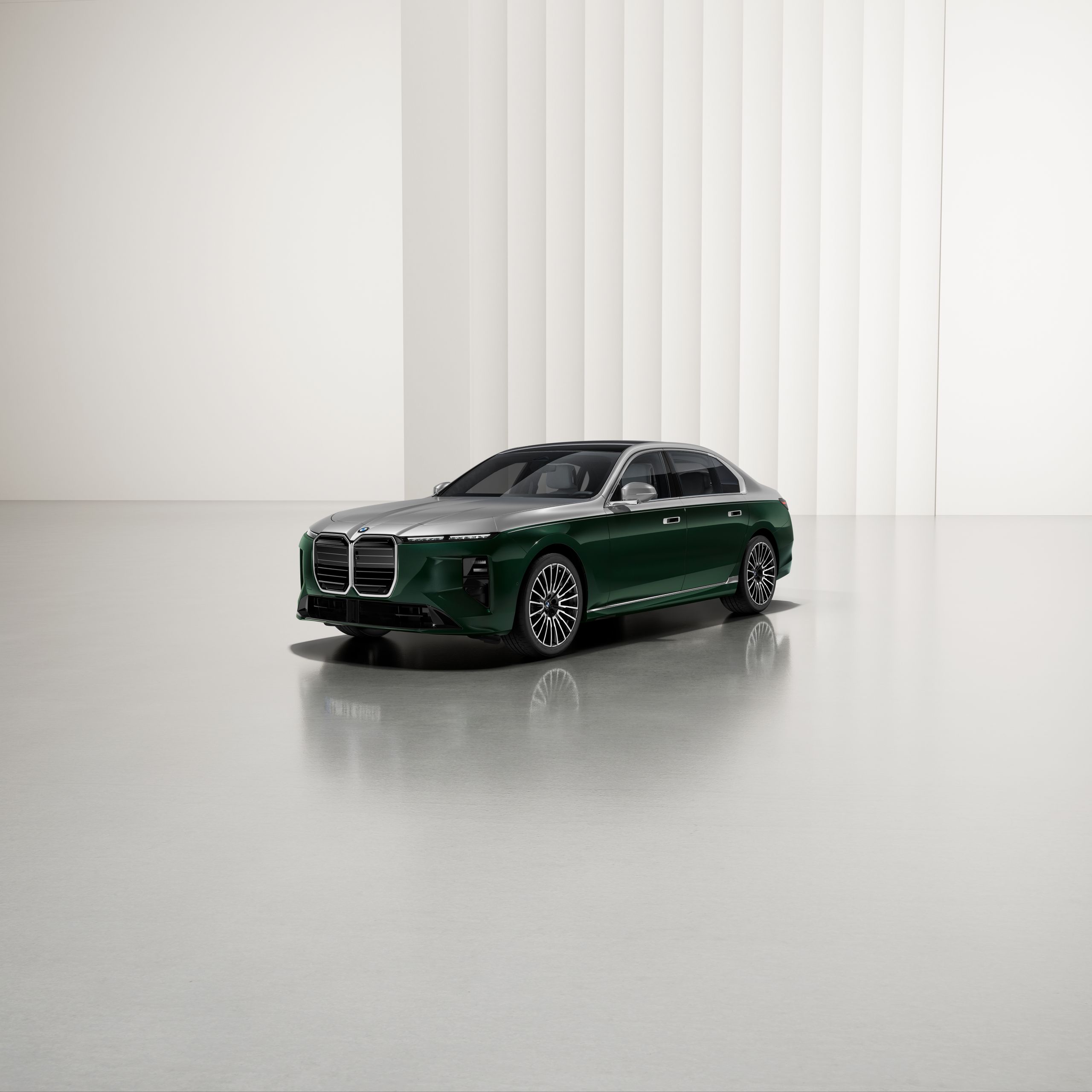 A BMW with two-tone paintwork at an angle on a reflective surface, with a modern background.