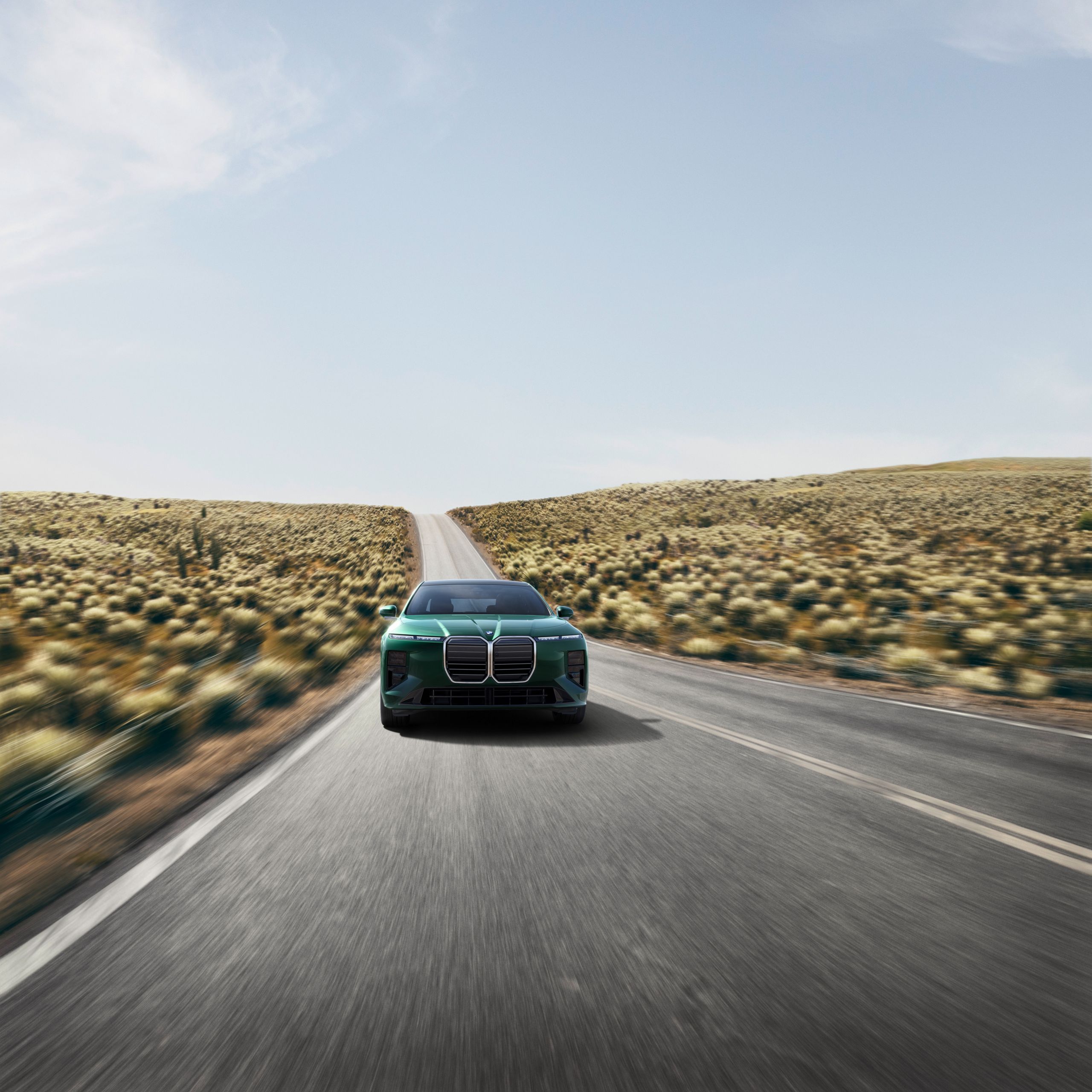 Vehicle drives towards the camera on a hilly highway.