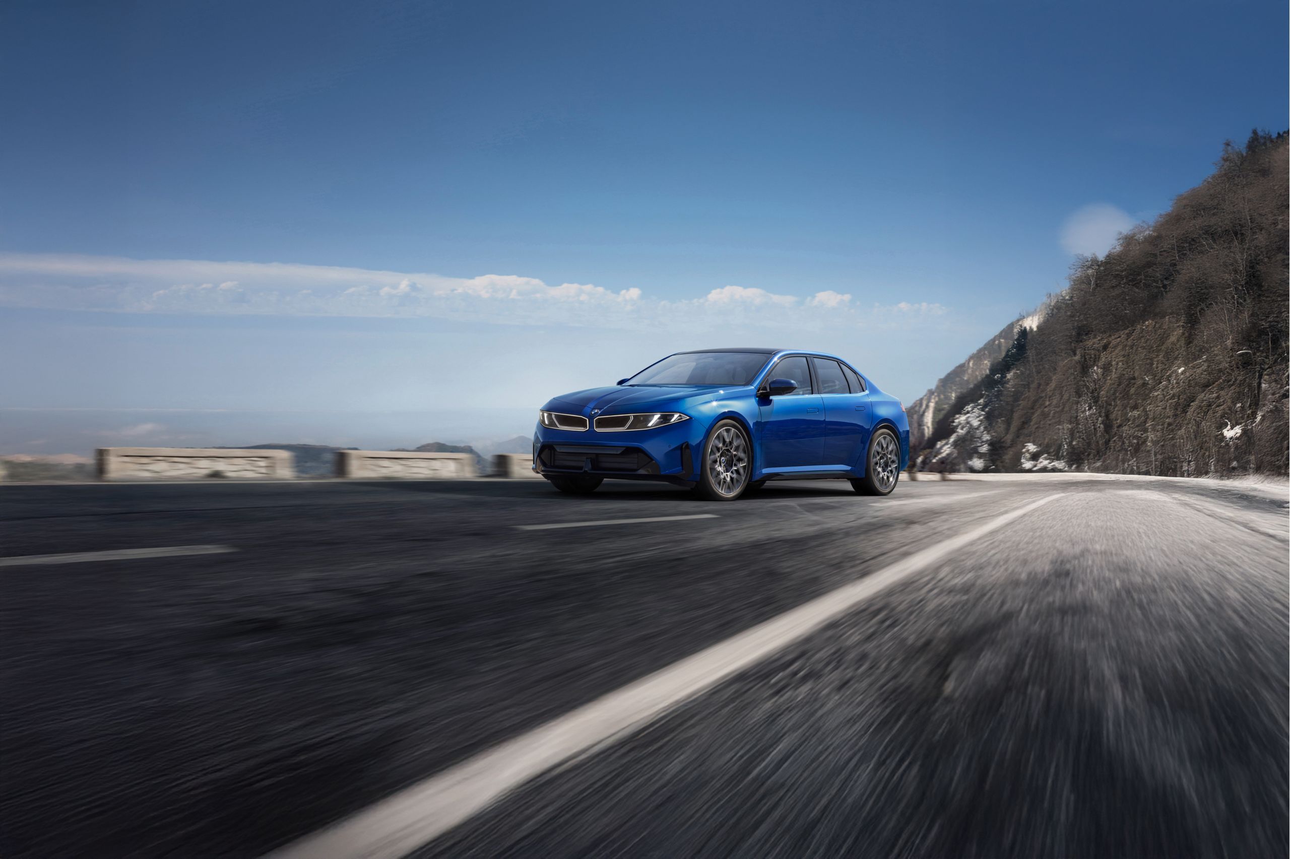 The BMW i3 Sedan drives along an urban highway through a modern city, while the vehicle is shown from various angles. The vehicle then drives along a winding road through a landscape of mountains and lakes.