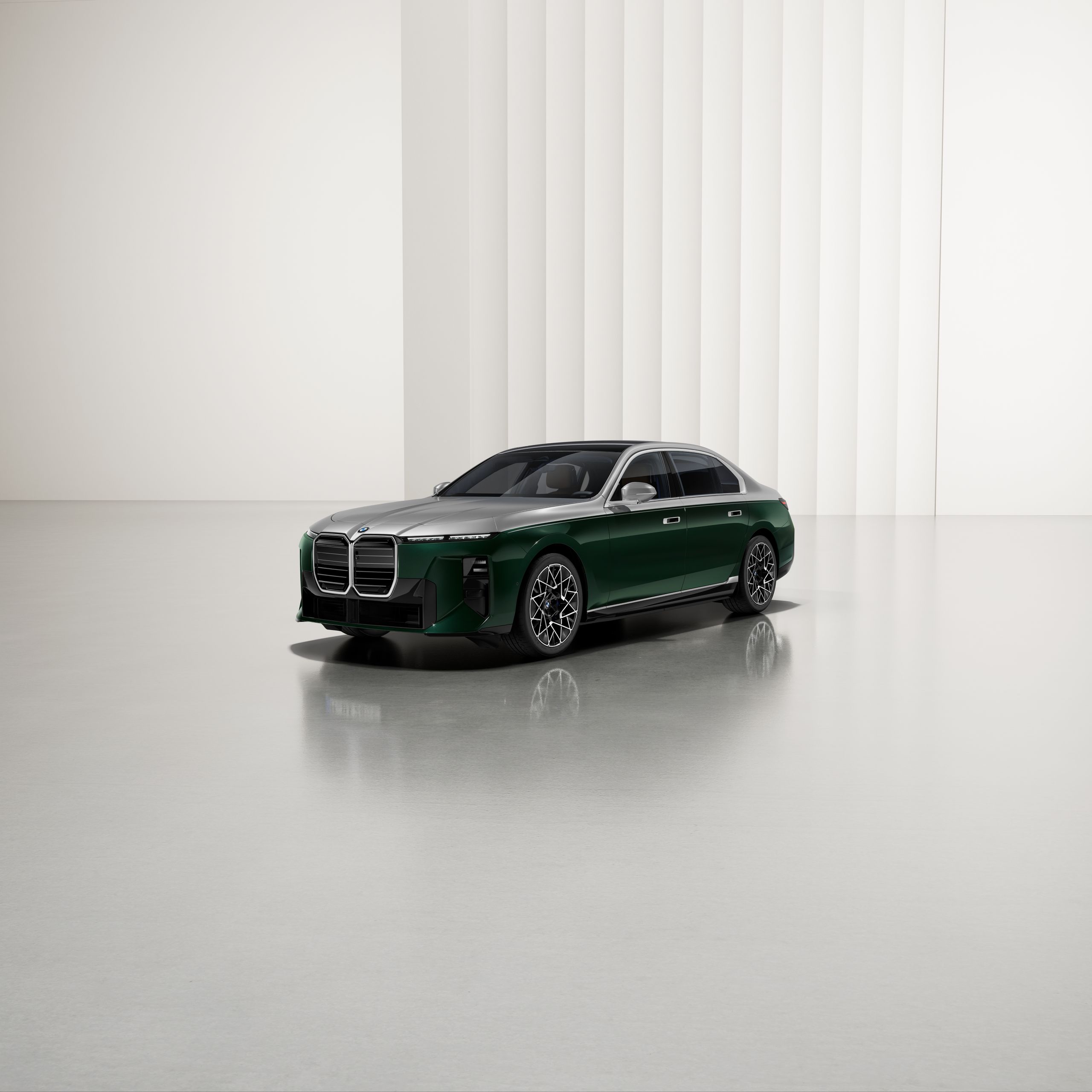 A BMW with two-tone paintwork at an angle on a reflective surface, with a modern background.