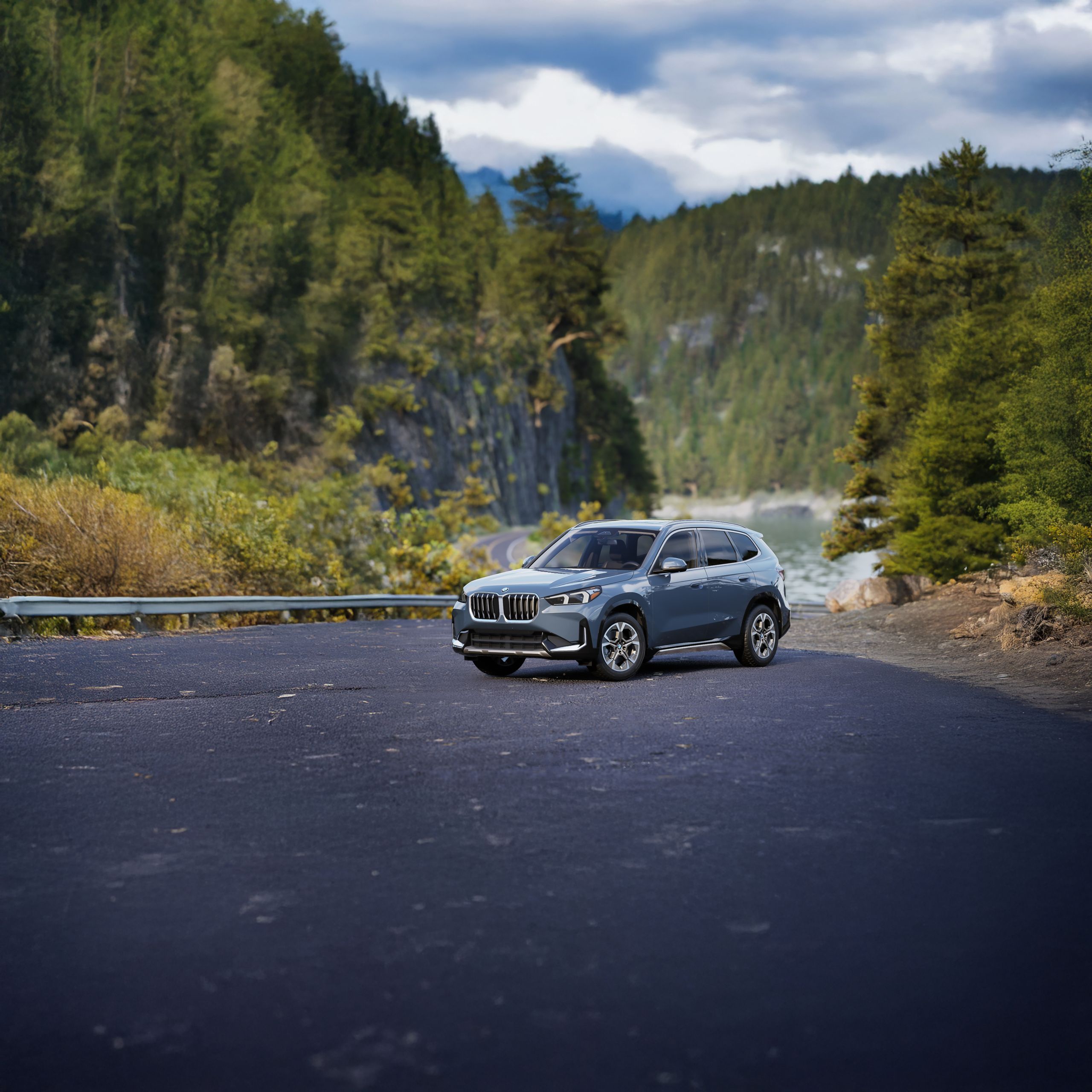 A BMW X1 parked on a mountain road with a rolling river in the background