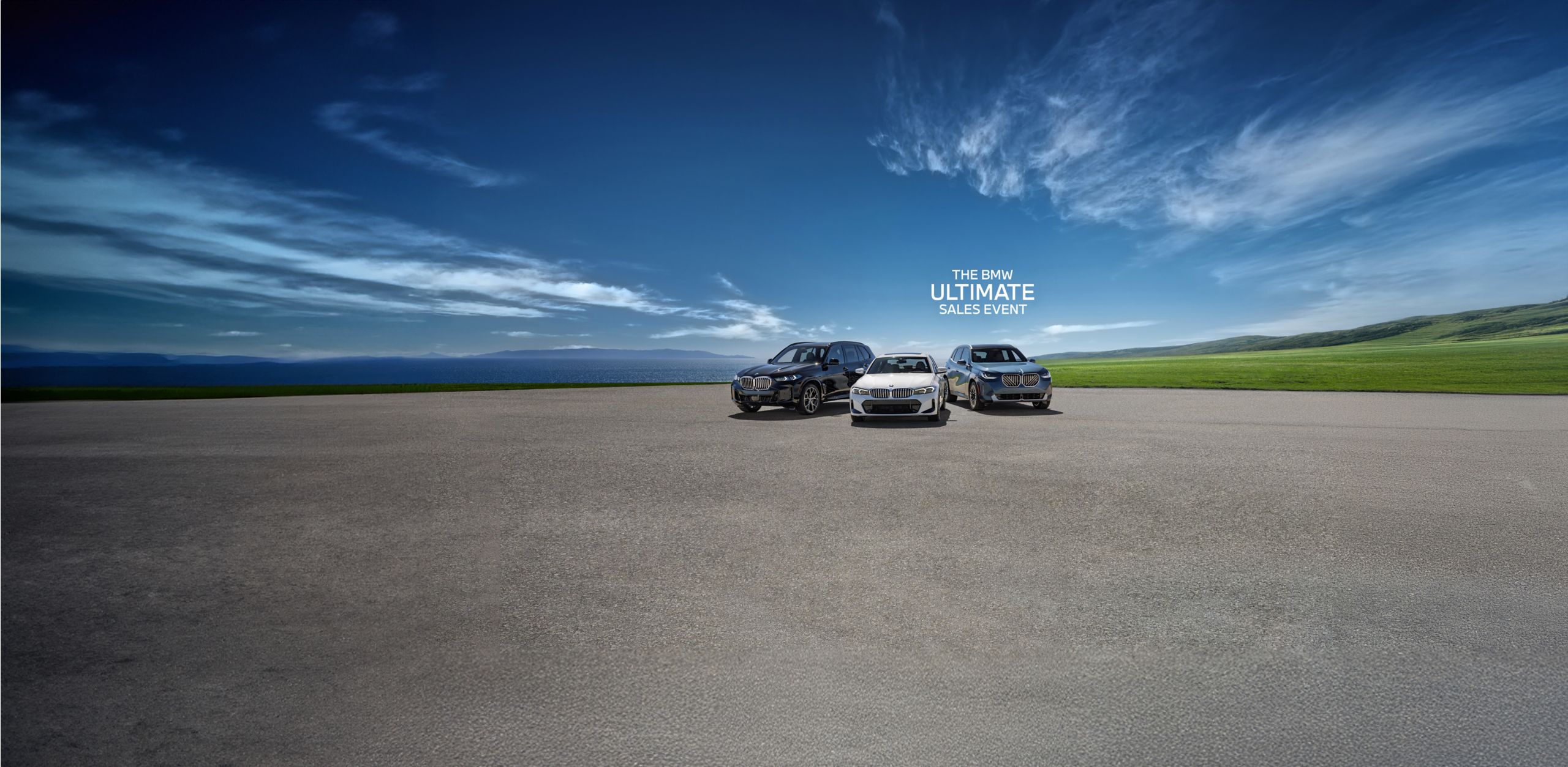 A BMW X3, 3 Series, and X5 parked in a paved area next to a large body of water