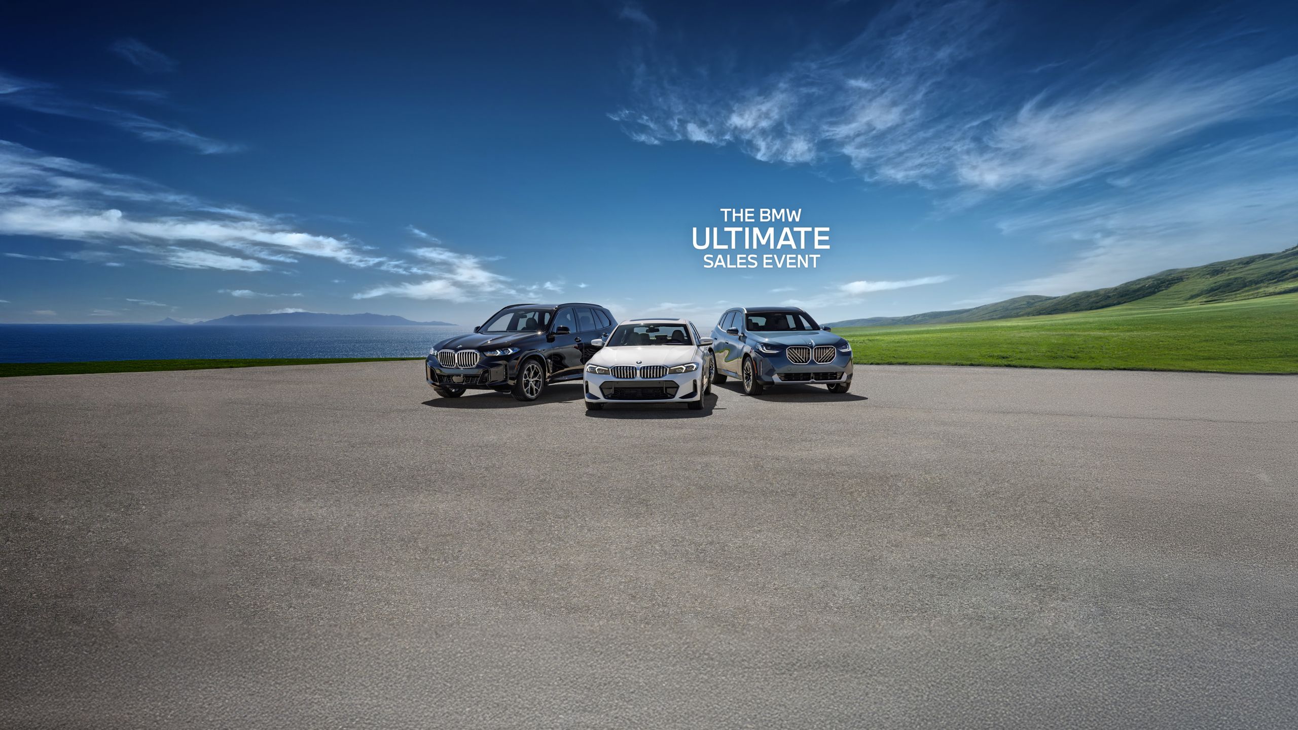A BMW X3, 3 Series, and X5 parked in a paved area next to a large body of water