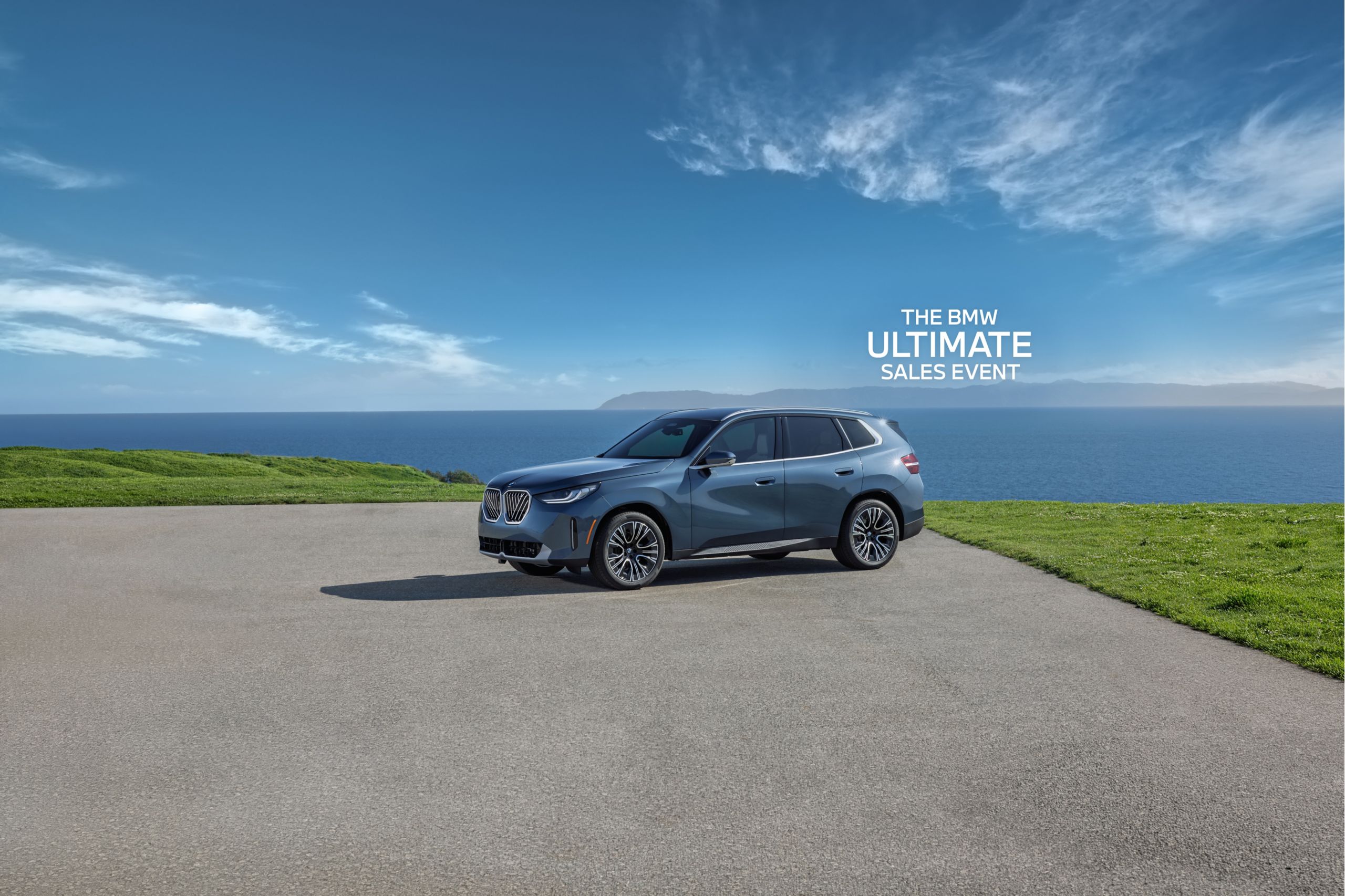 The BMW X3 parked on a paved area in front of a large body of water.