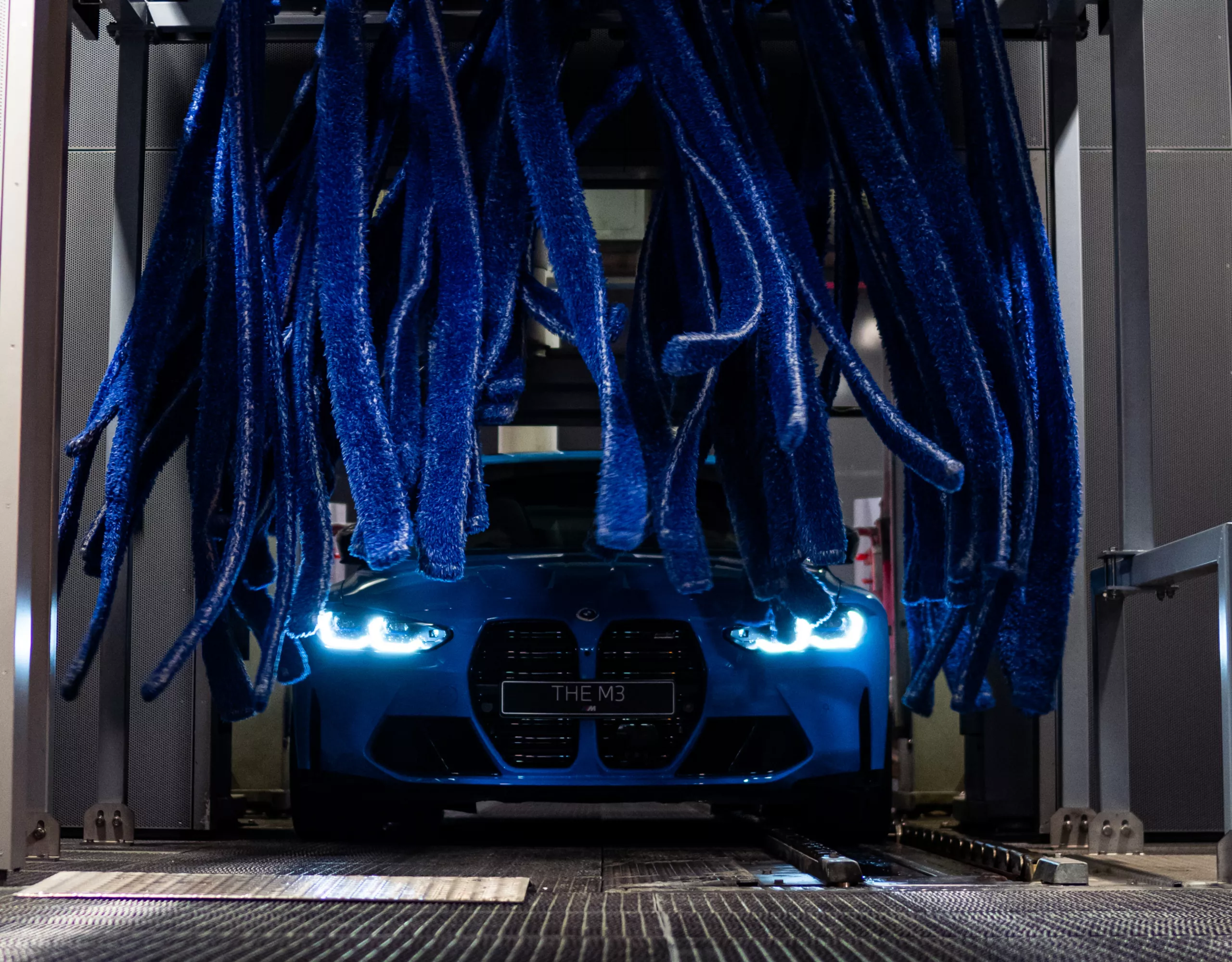 Blue BMW gets a cleaning in the car wash