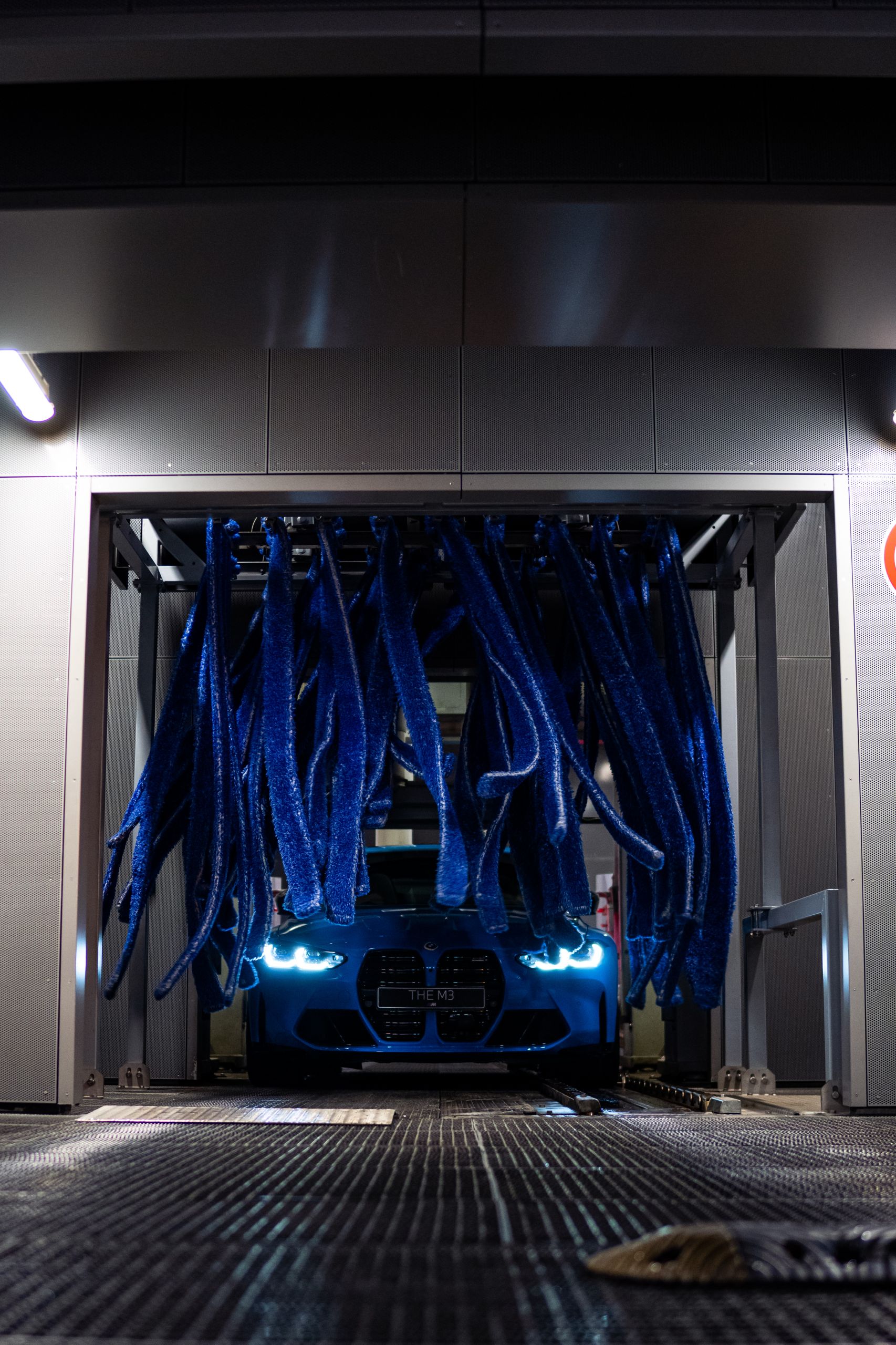 Blue BMW gets a cleaning in the car wash