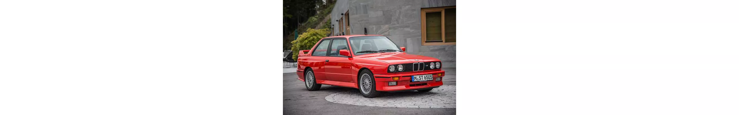 En röd BMW M3 parkerad på gatan.