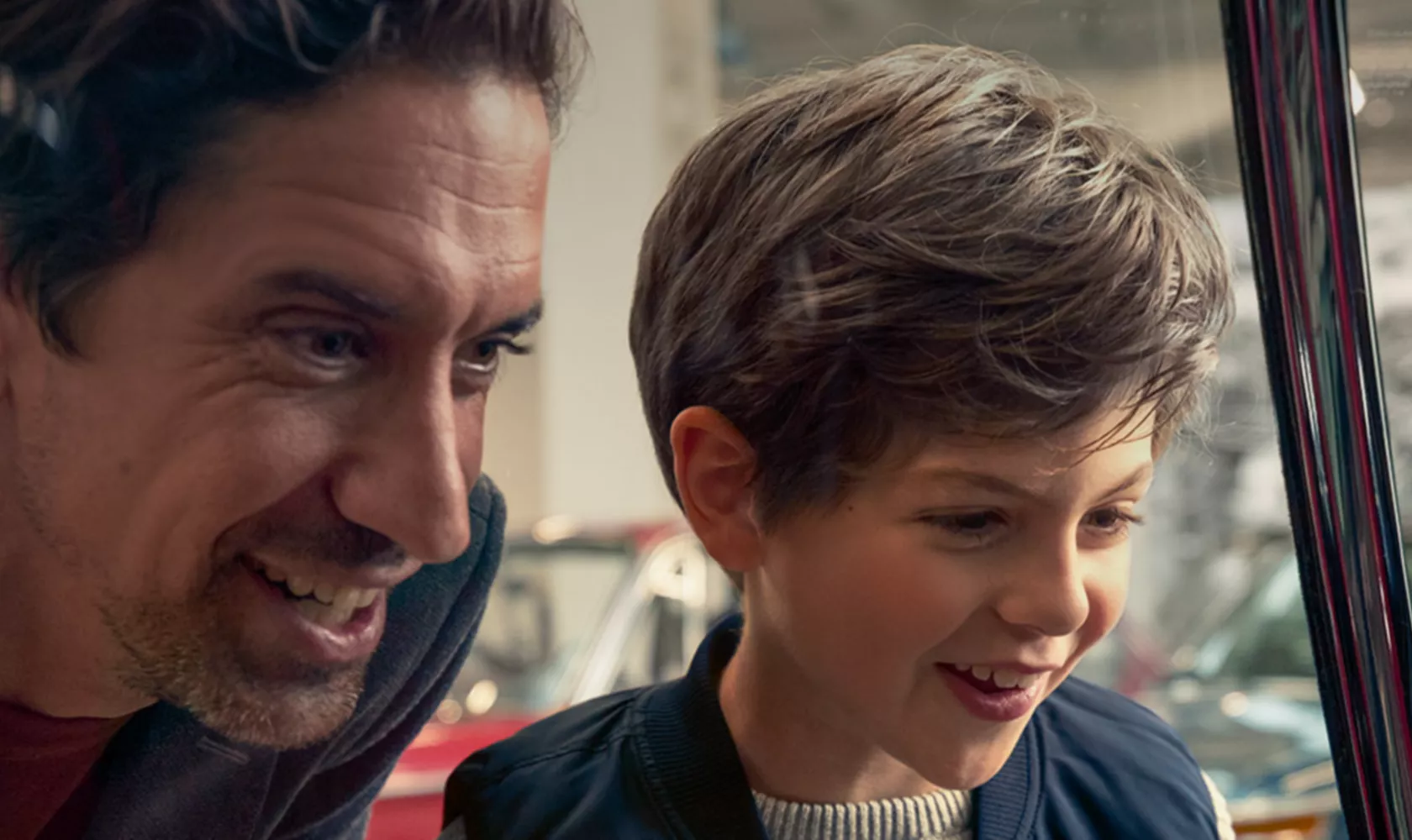 Father and son look enthusiastically through side window of a BMW