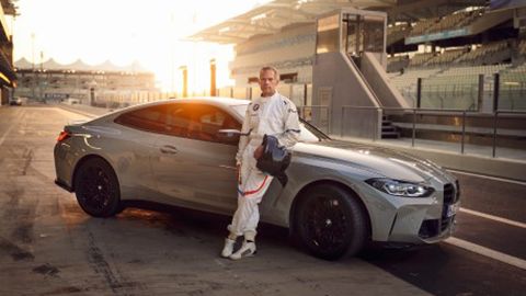 3 quarter shot of BMW with man leaning on car