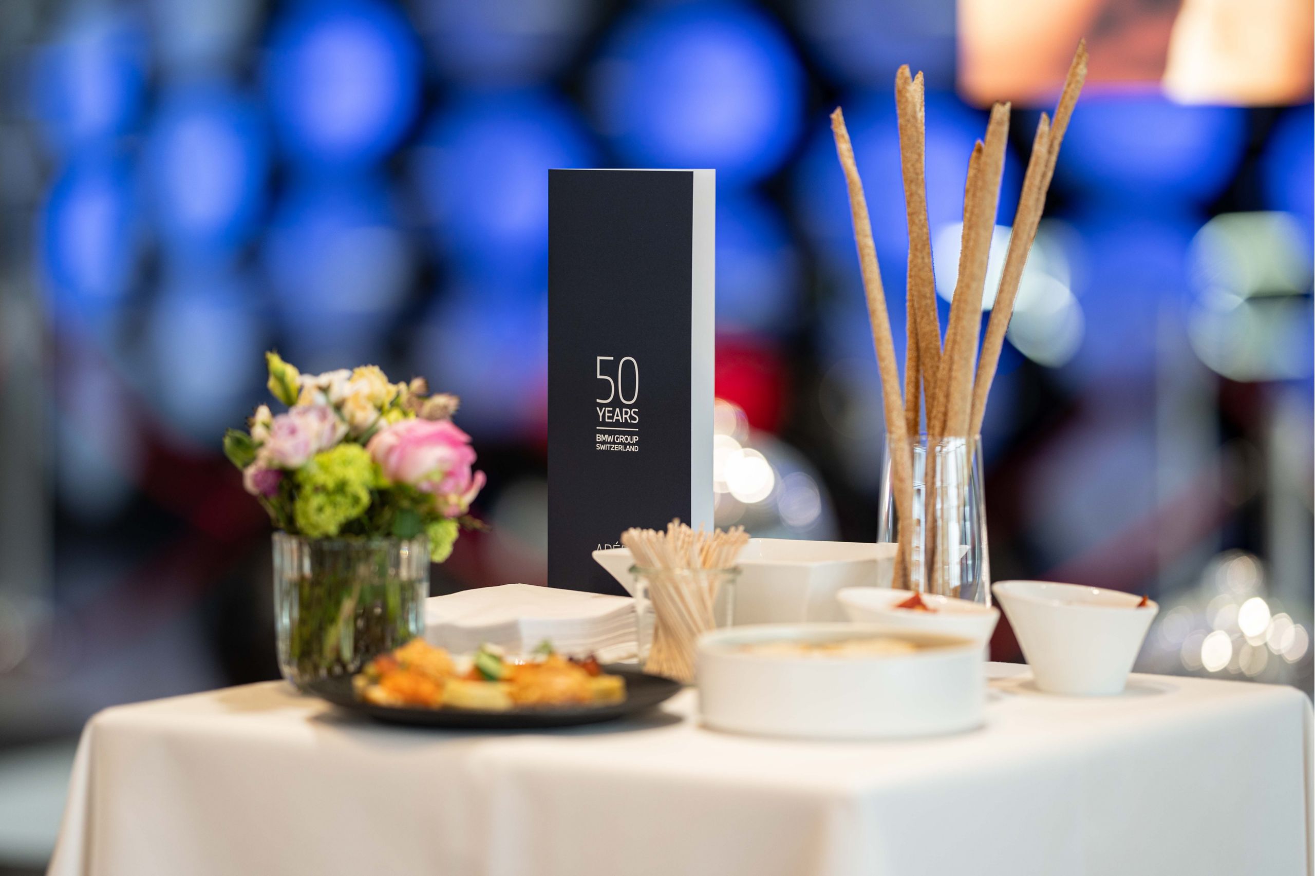 Menu portant l’imprimé 50 ans de BMW Group Switzerland entouré d’éléments décoratifs
