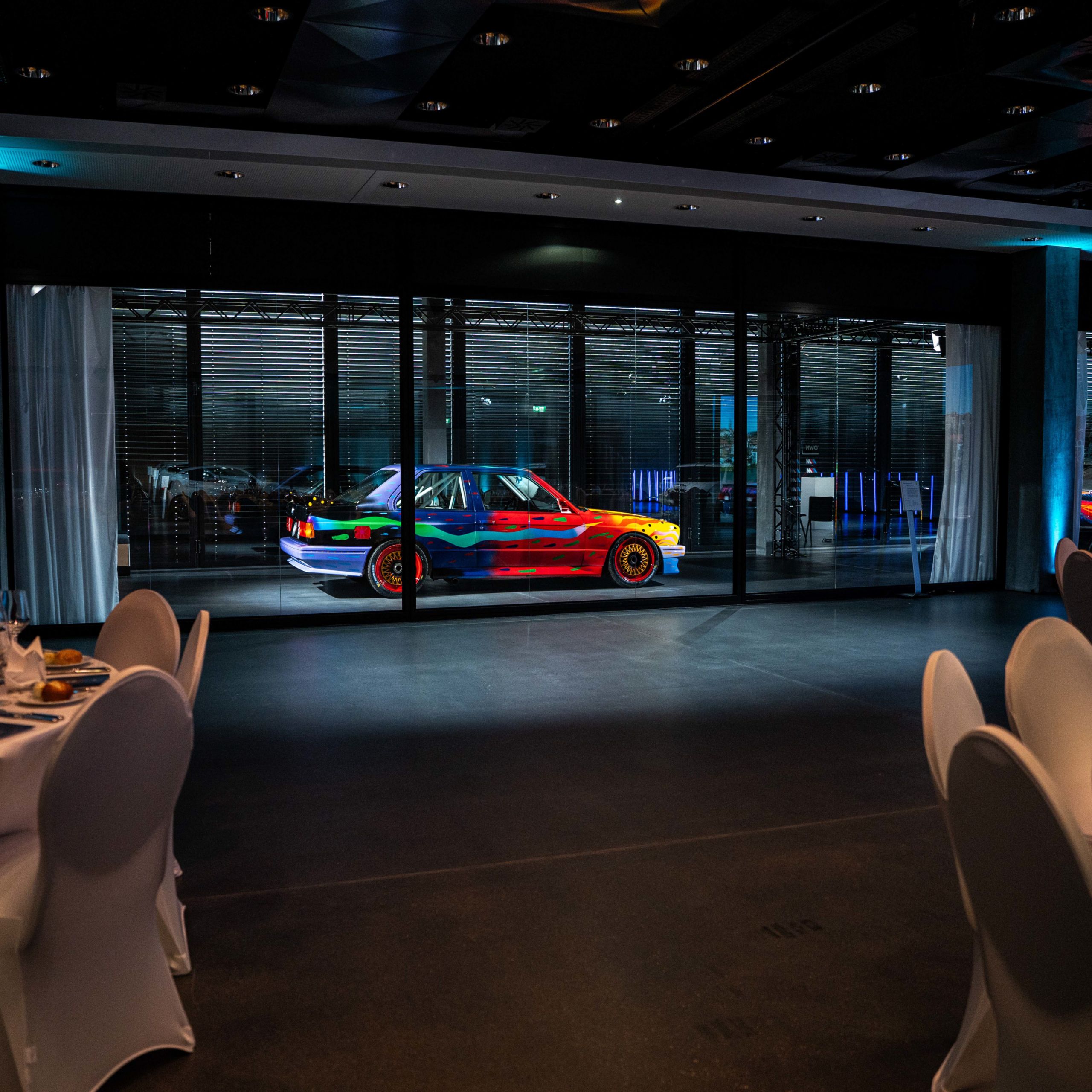 Vue de côté de la BMW Art Car no 8 colorée de Ken Done, illuminée dans l’obscurité
