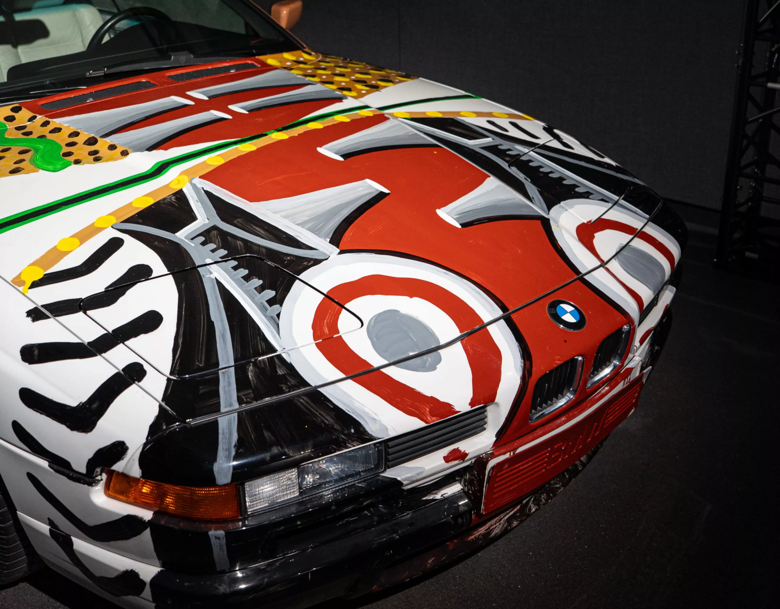 Vista frontale con focus sulla copertura vano motore della BMW Art Car di David Hockney con colorati motivi dipinti