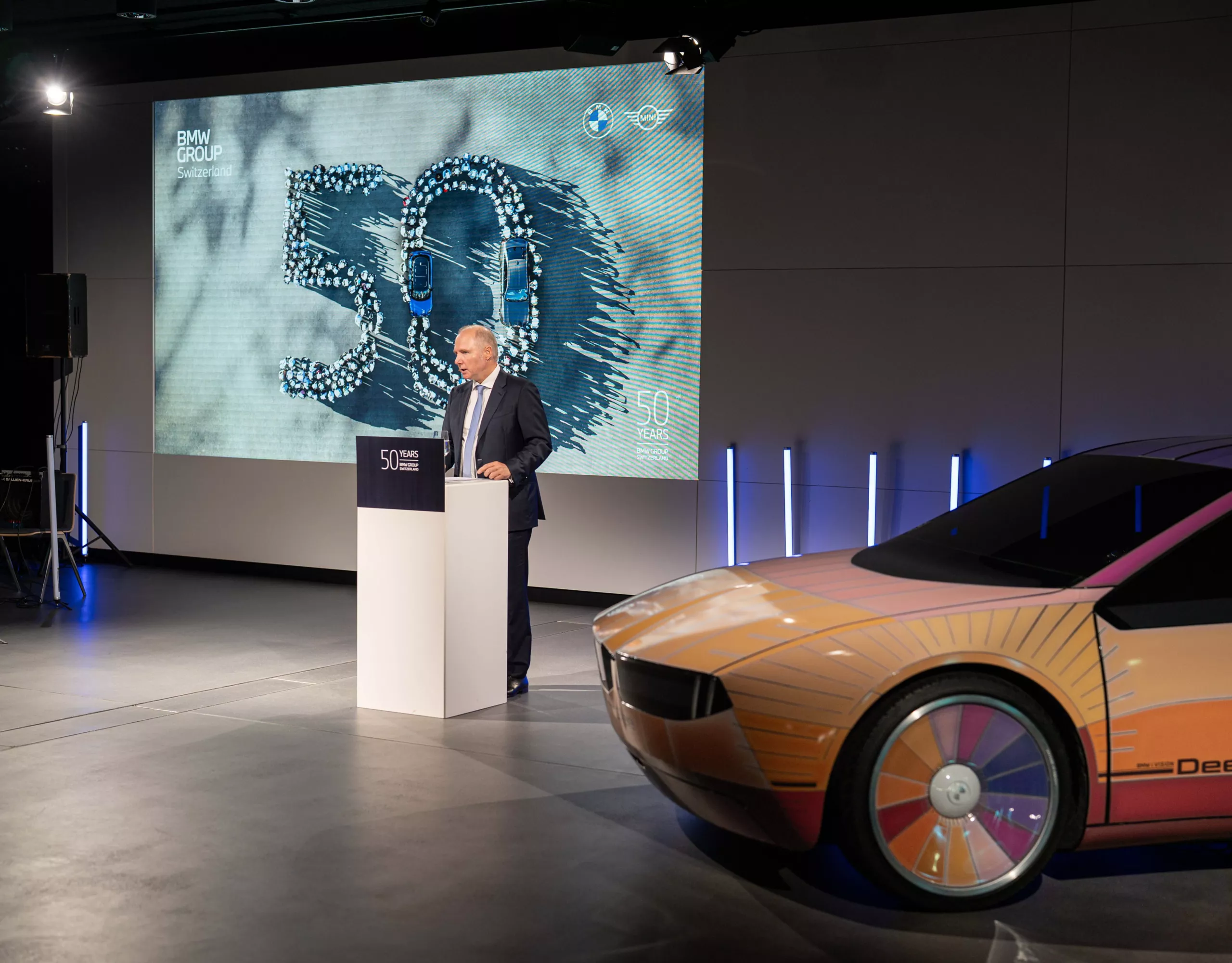 Jochen Goller, membro del consiglio di amministrazione di BMW, al podio dell’oratore accanto a una concept car BMW i Vision Dee