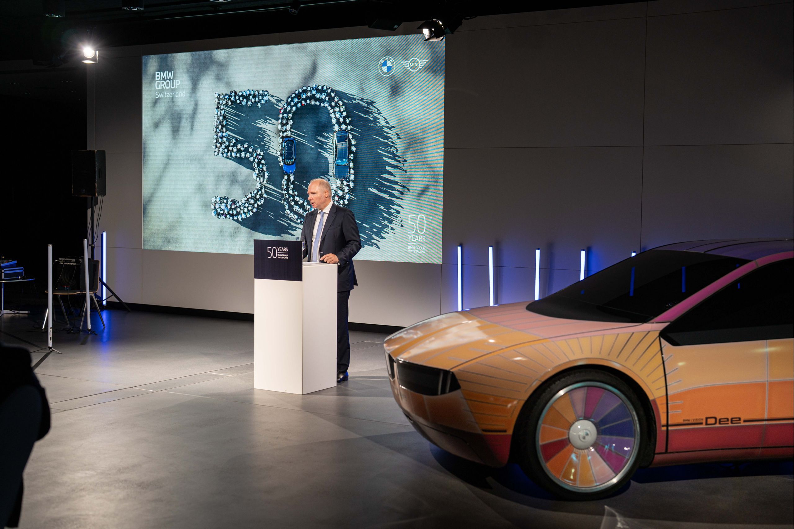 Jochen Goller, membre du comité de direction de BMW, se tient à un pupitre à côté d’un concept-car BMW i Vision Dee