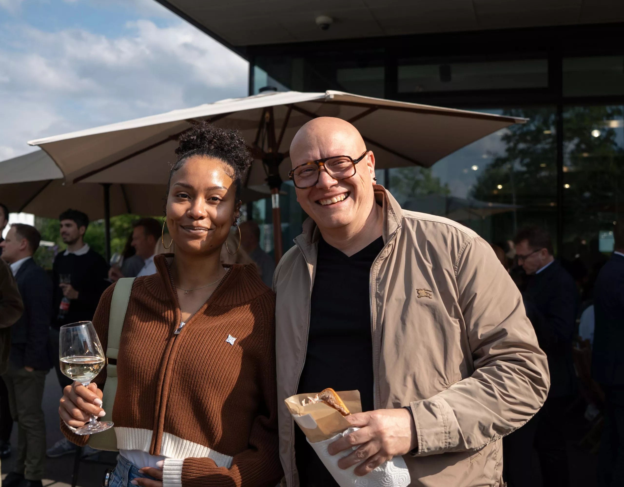 Una donna e un uomo sorridono fianco a fianco con lo sguardo verso la telecamera
