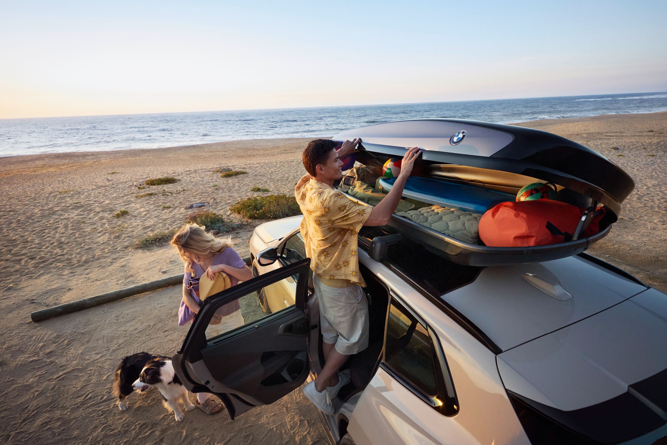 BMW with open trunk parking on the beach