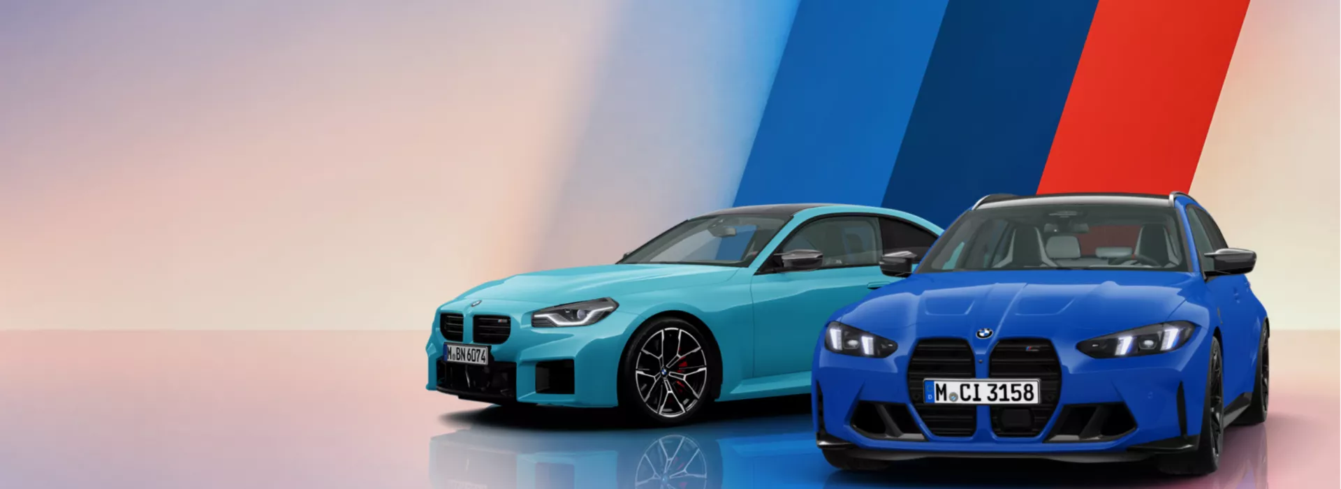 Der BMW M3 Competition Touring und der BMW M2 sind nebeneinander vor einem abstrakten Hintergrund in den BMW M Farben positioniert. Beide BMW M Modelle werden aus schräger Frontansicht gezeigt und spiegeln sich auf dem glänzenden Untergrund.