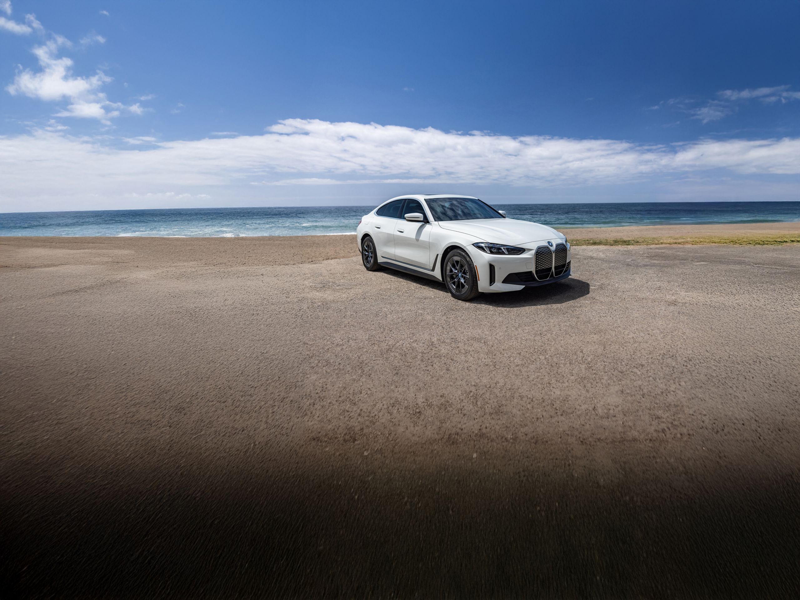 A 2025 i4 eDrive40 Gran Coupe parked at the beach on a sunny day