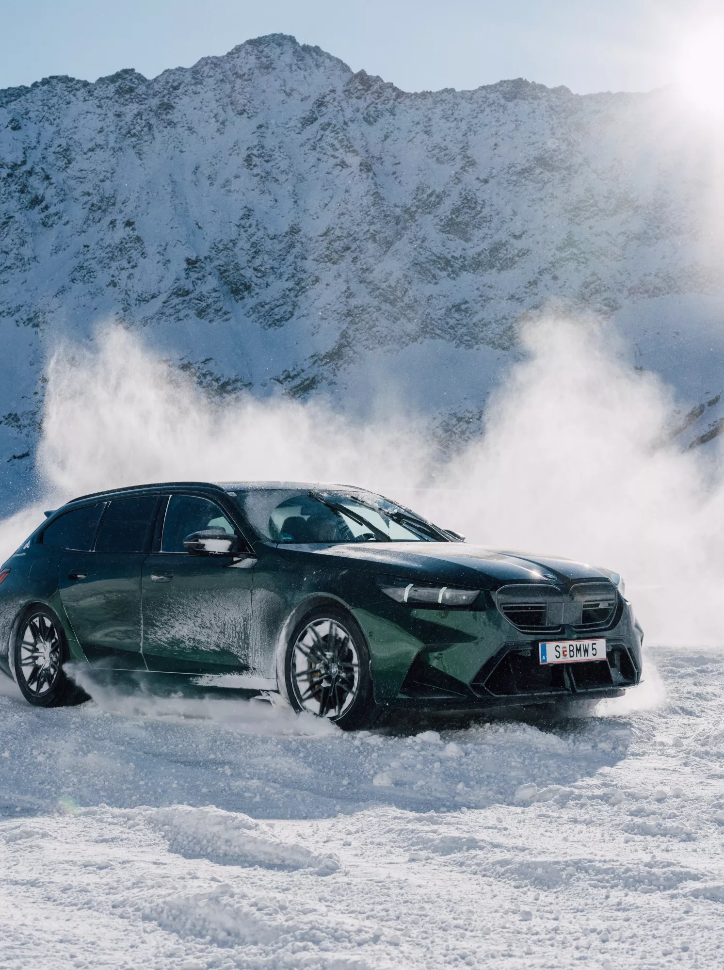 Green sport car drifting on snowy terrain