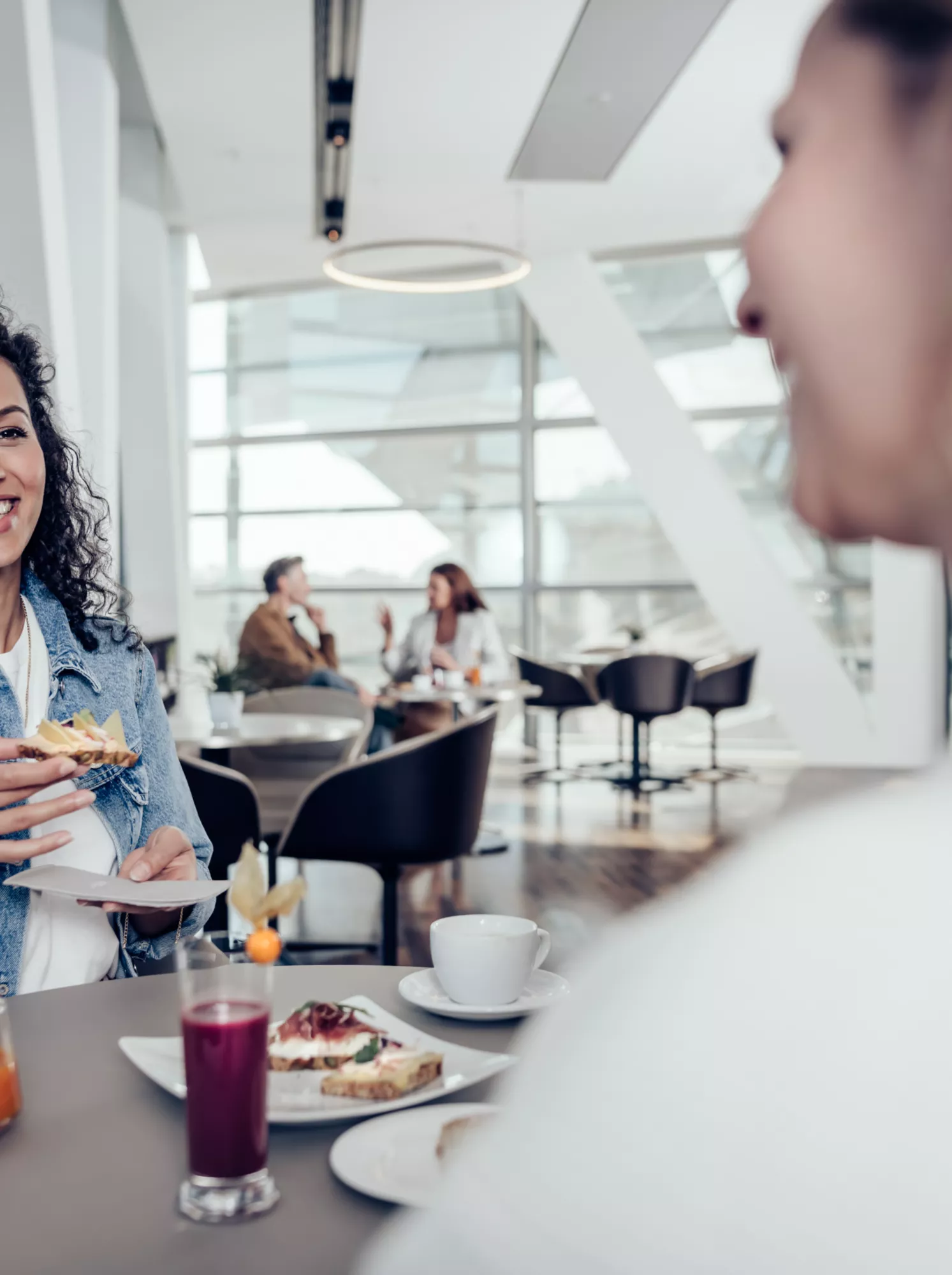 Zwei Frauen genießen Speisen in der Premium Lounge der BMW Welt