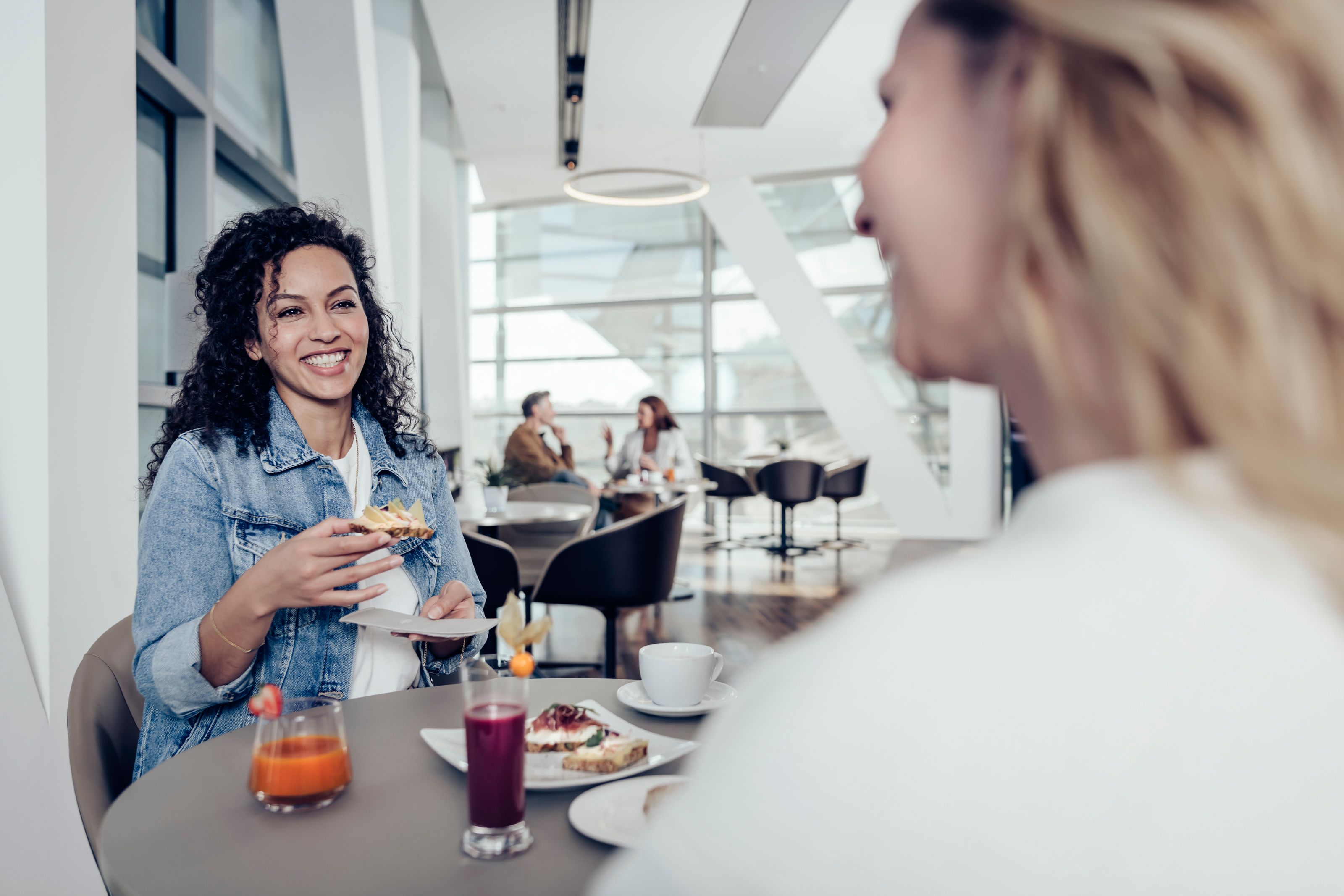 Zwei Frauen genießen Speisen in der Premium Lounge der BMW Welt