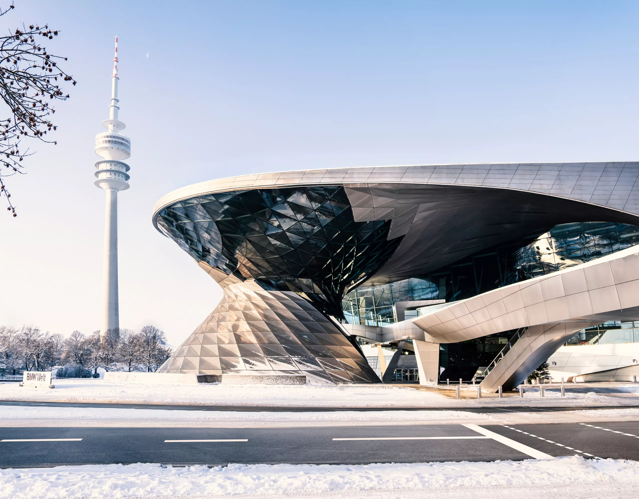 Exterior view of BMW Welt in winter, surrounded by a snowy landscape.