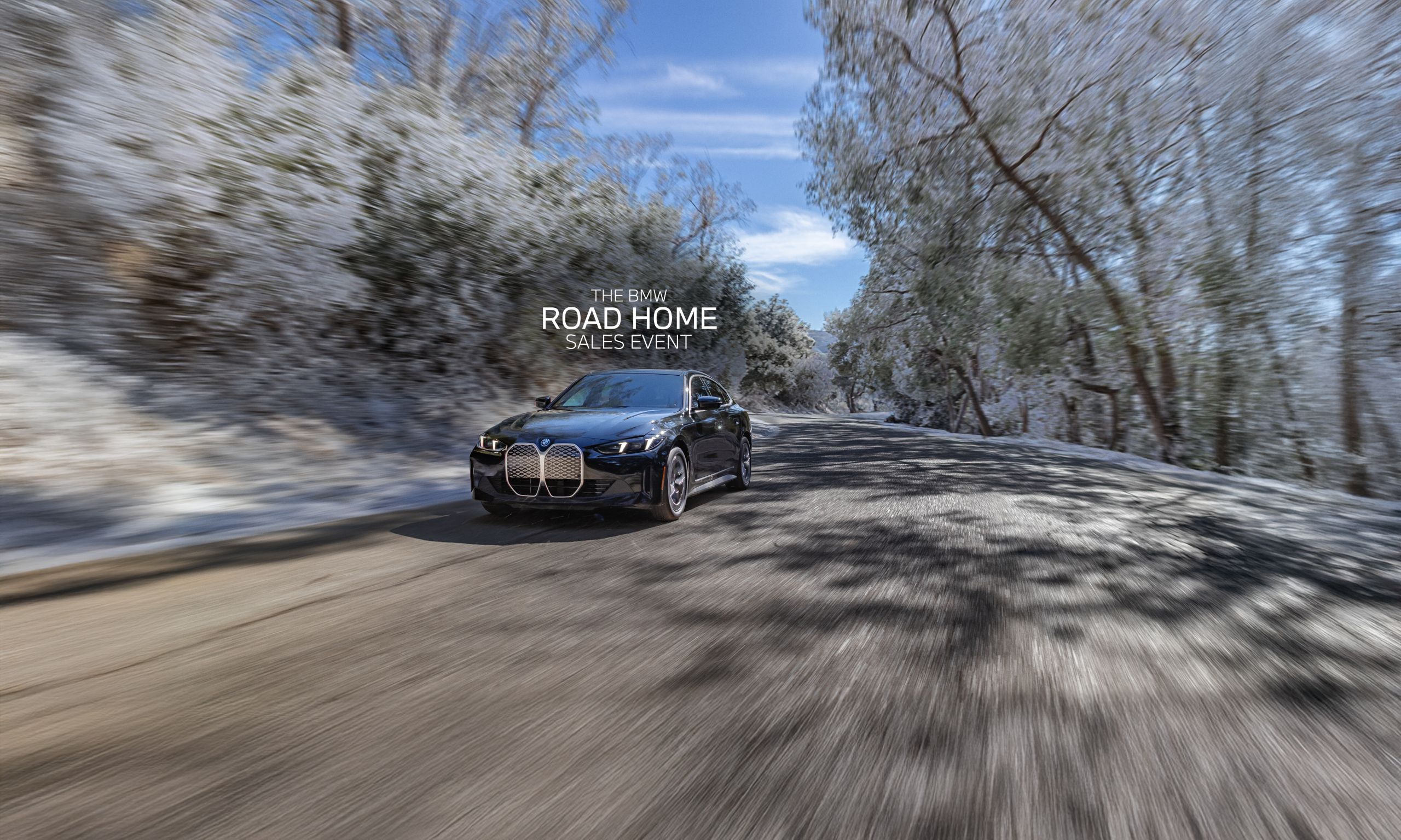 Dynamic shot of the 2025 BMW i4 eDrive40 Gran Coupe driving down a scenic road