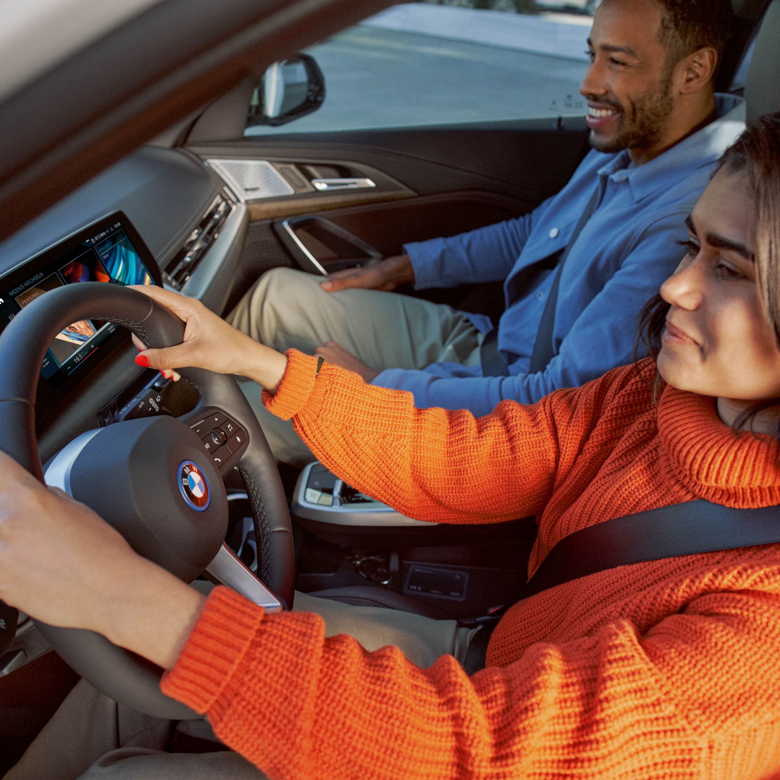 En kvinna och en man i en BMW.