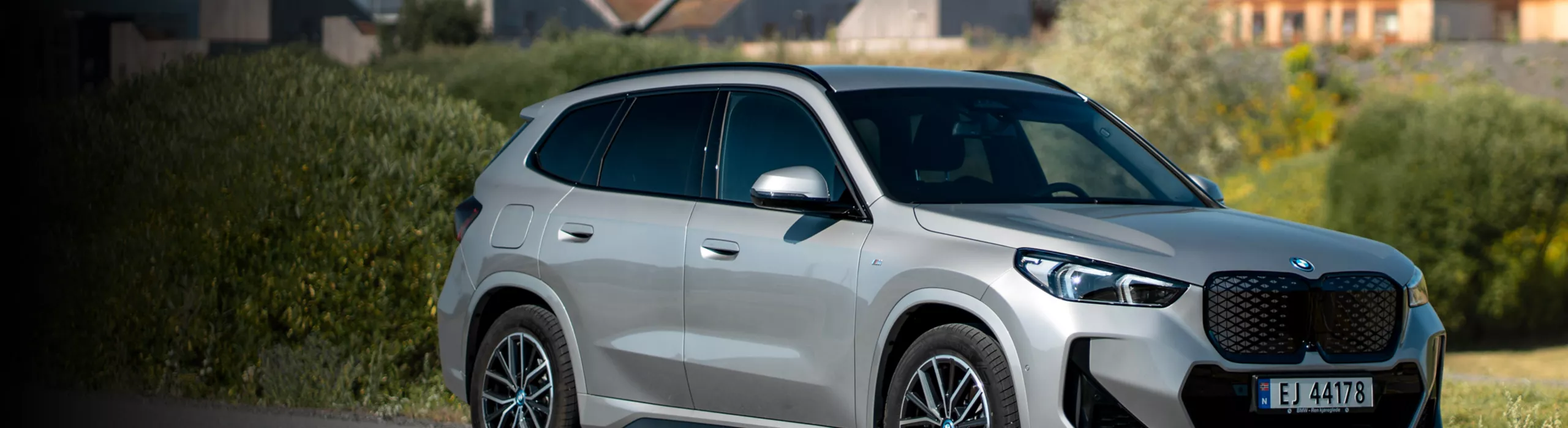 En blå BMW iX3 parkert som lades
