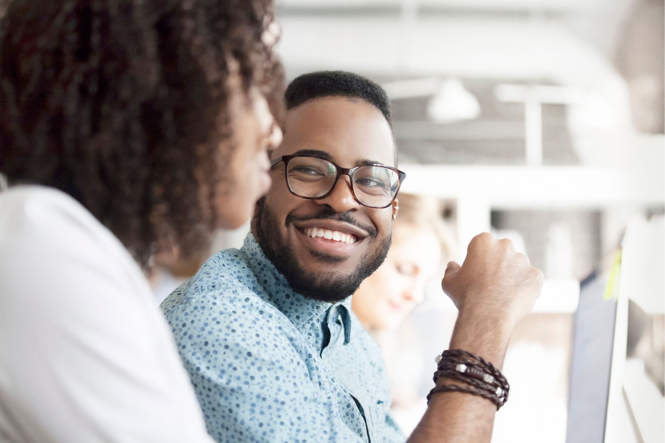 A student smiling at a woman in the foreground