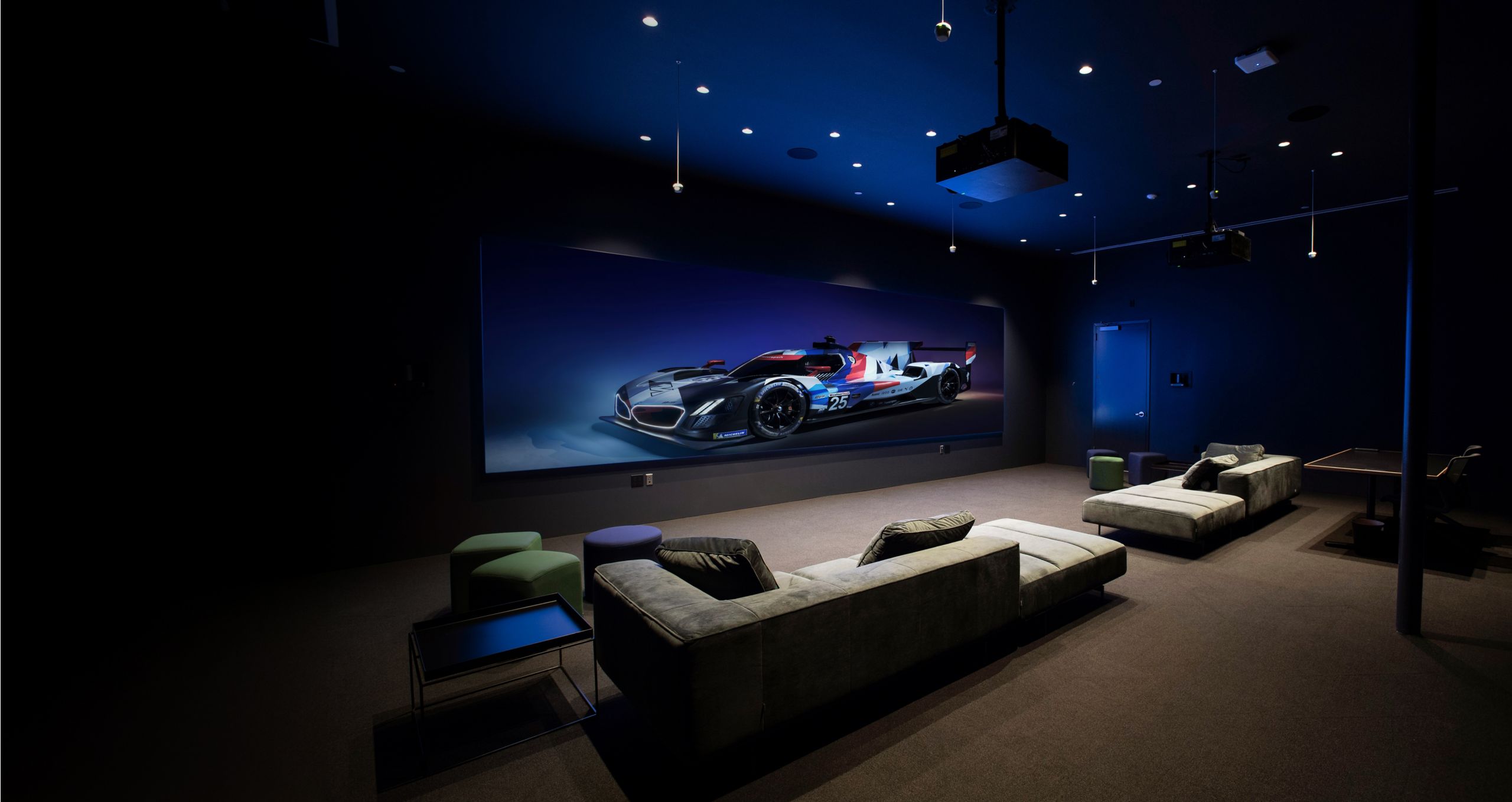 A corporate studio space with two coaches and a large image of a BMW racecar
