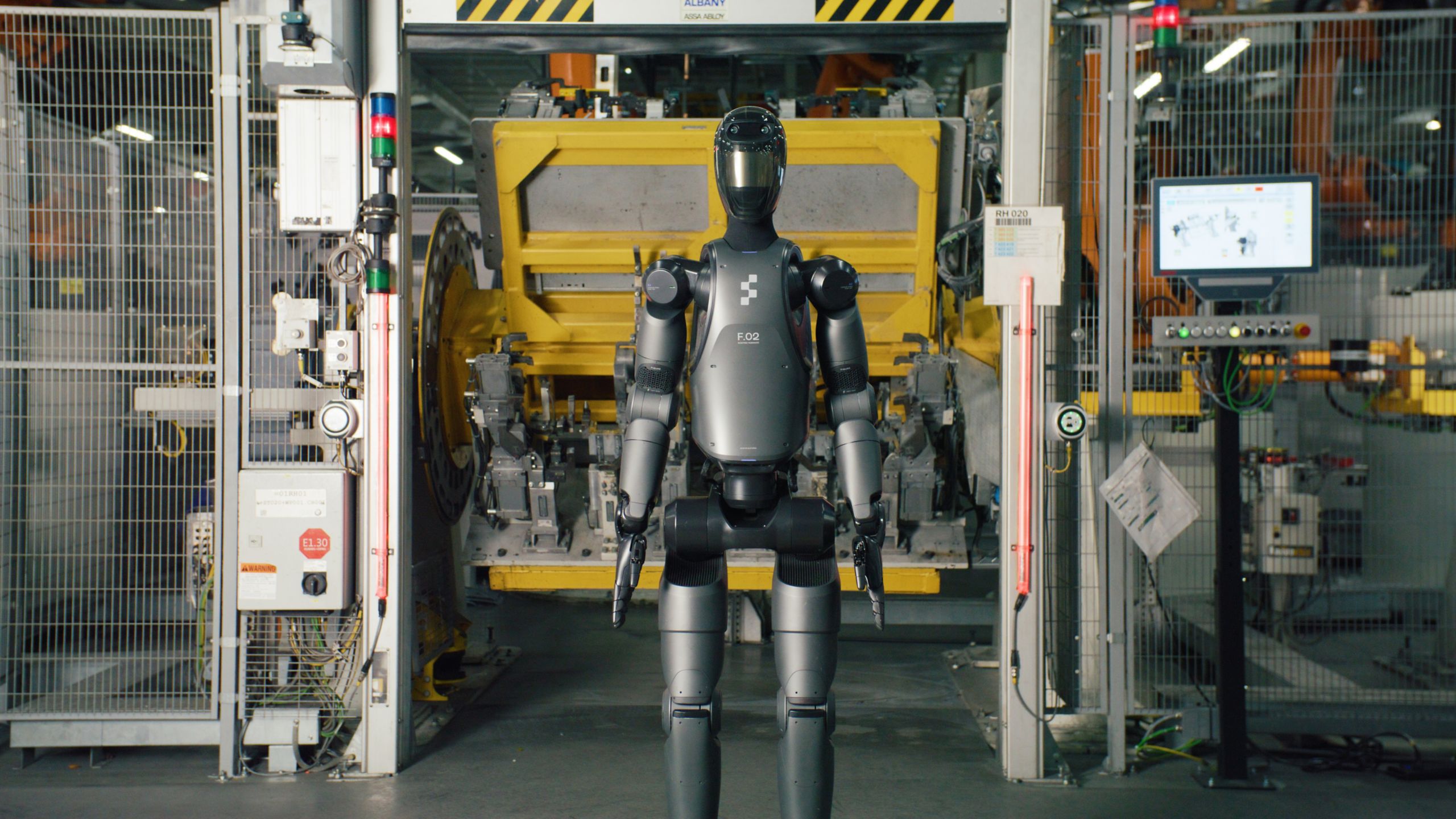 A humanoid robot stands inside a factory