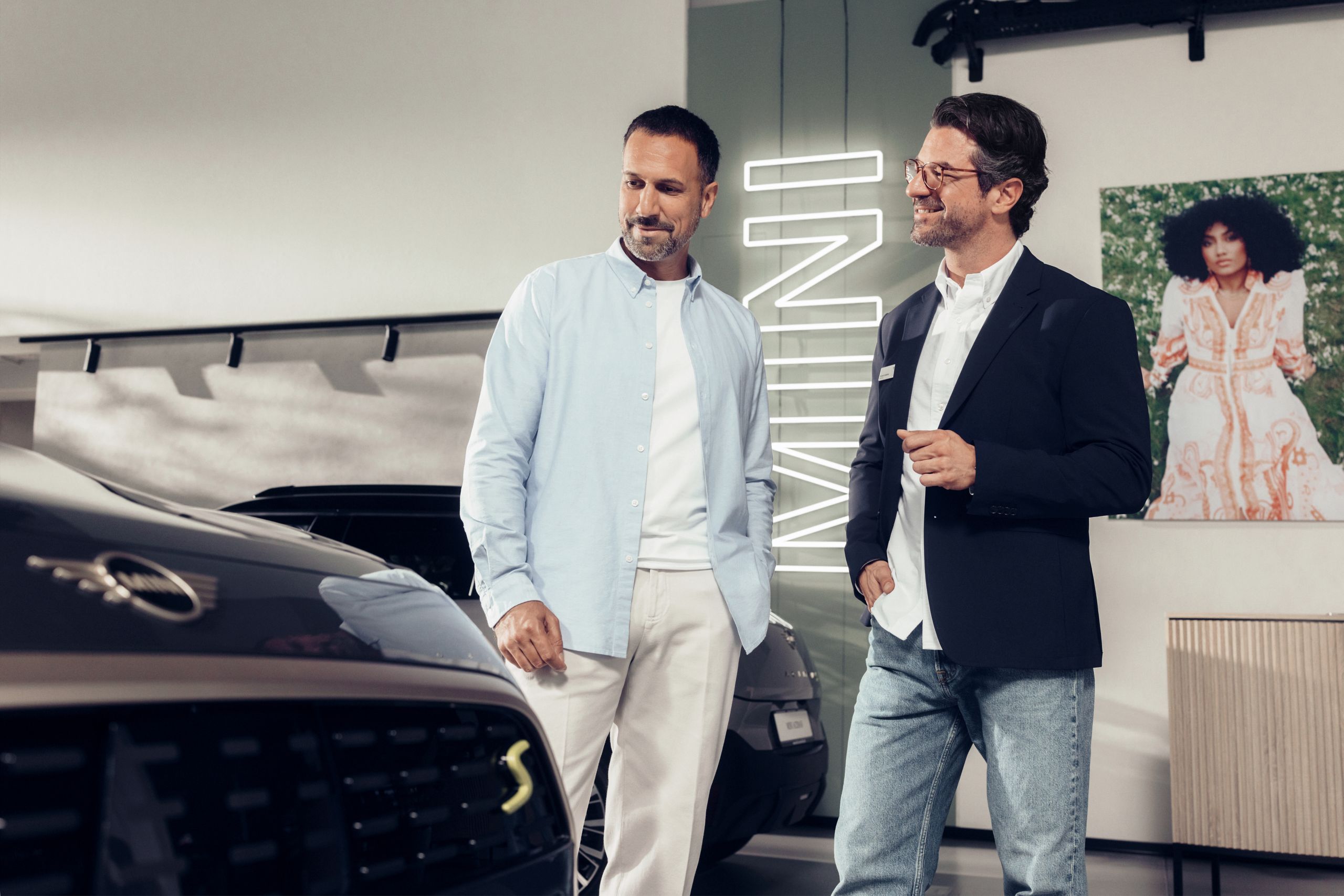 A customer admires a MINI as a MINI sales representative looks at him