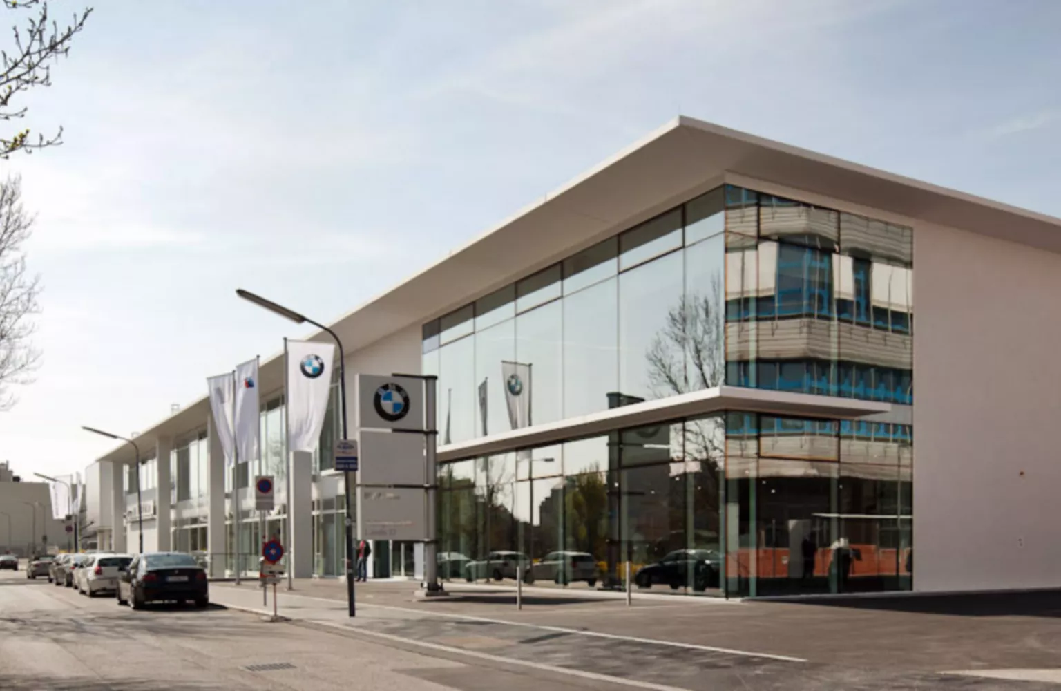 Seitenansicht der BMW Group Niederlassung Wien, bei der die große Fensterfront im Mittelpunkt des Bildes steht.