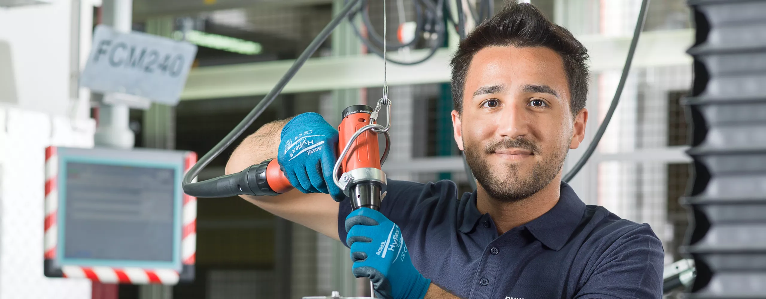 Ein Mitarbeiter des BMW Group Werk Steyr arbeitet gerade in einer Fertigungsstraße an einem Verbrennungsmotor der BMW Group.