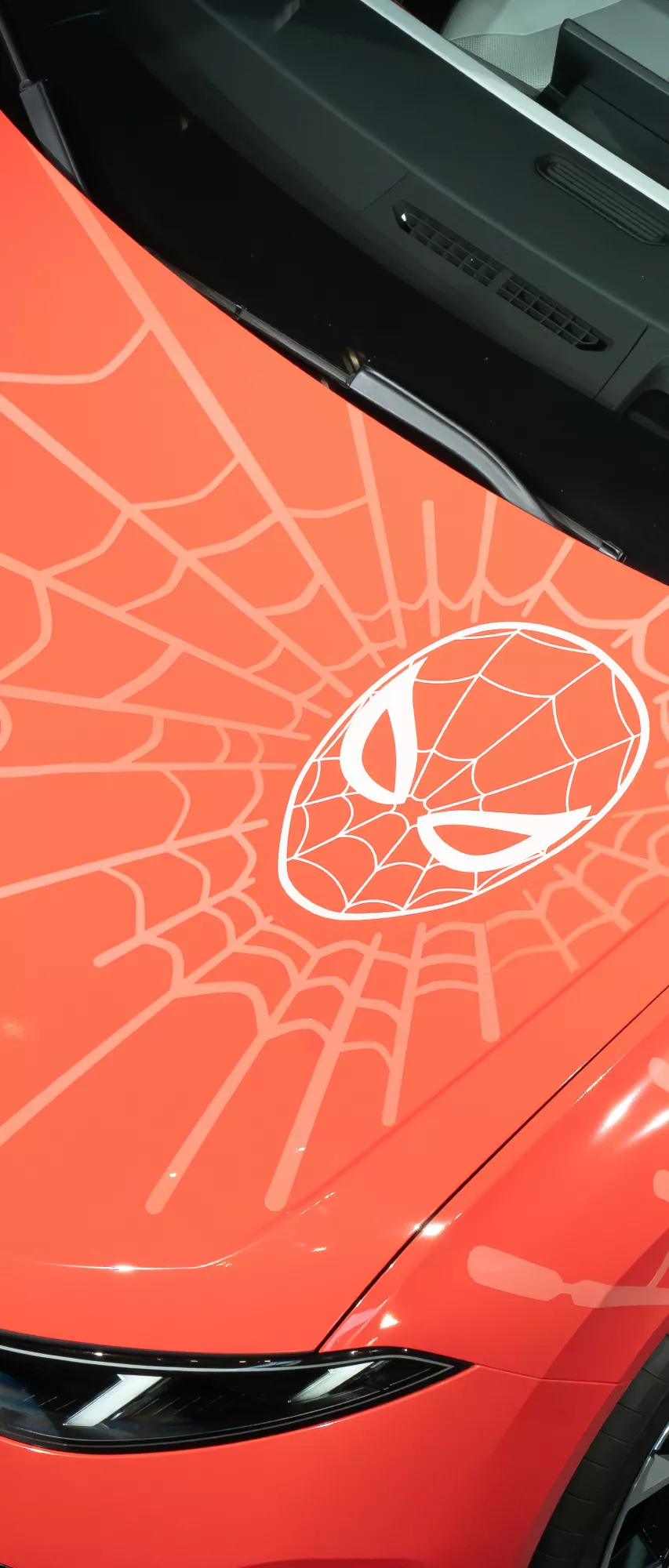 Close-up of the BMW iX3 Flow Spider-Man™ featuring a Spider-Man motif and spider web graphic on the hood.