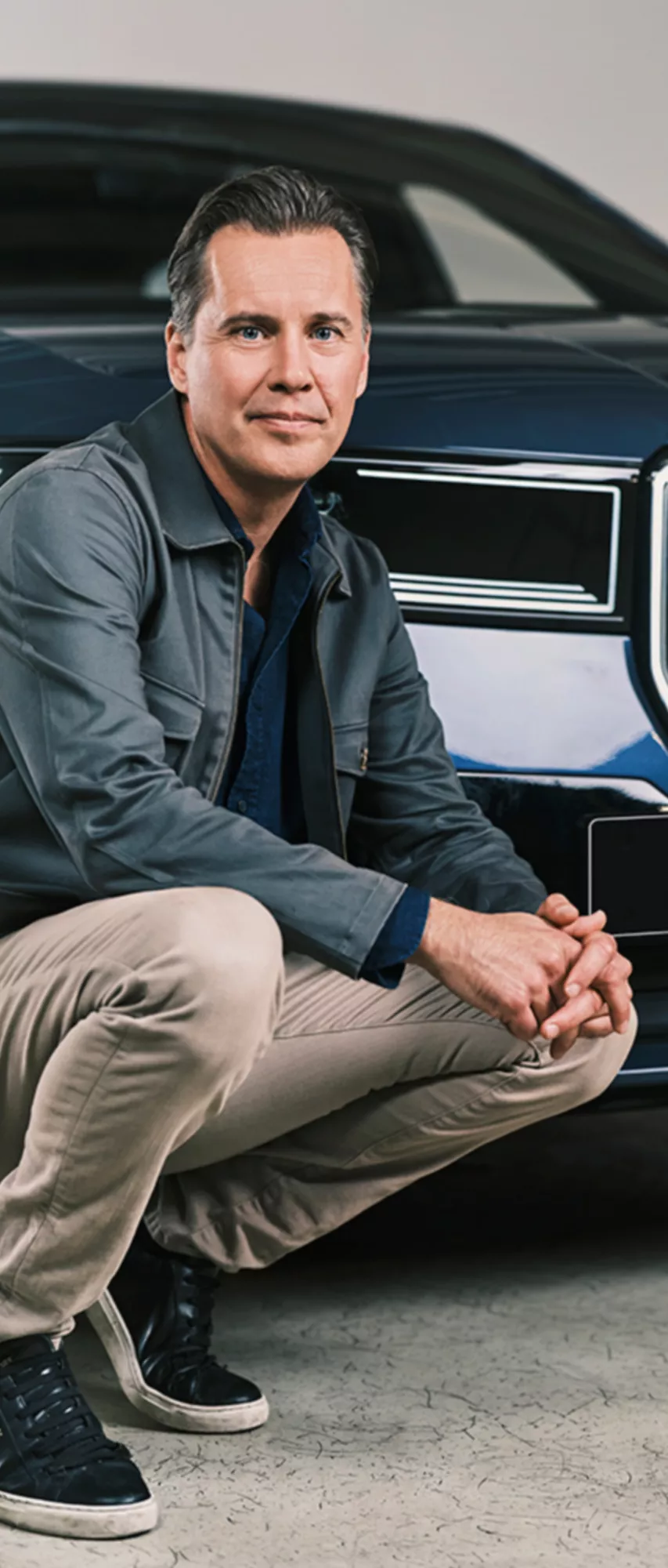 Carl Lindwall står framför en blå BMW iX3