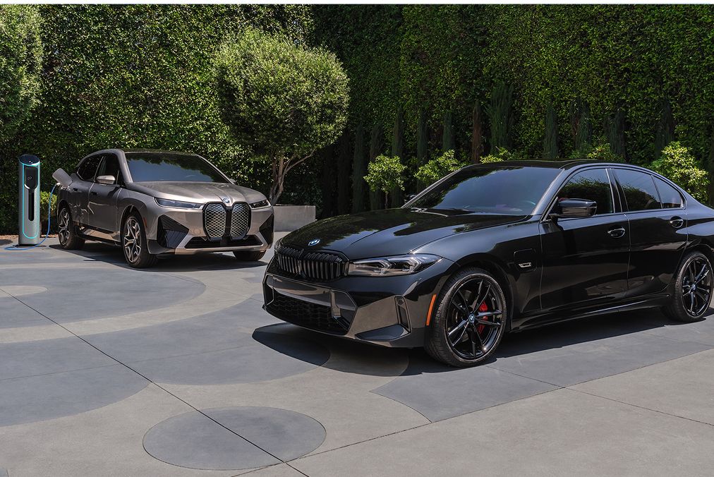 A BMW Certified iX SUV and 3 Series Sedan parked side by side on pavement