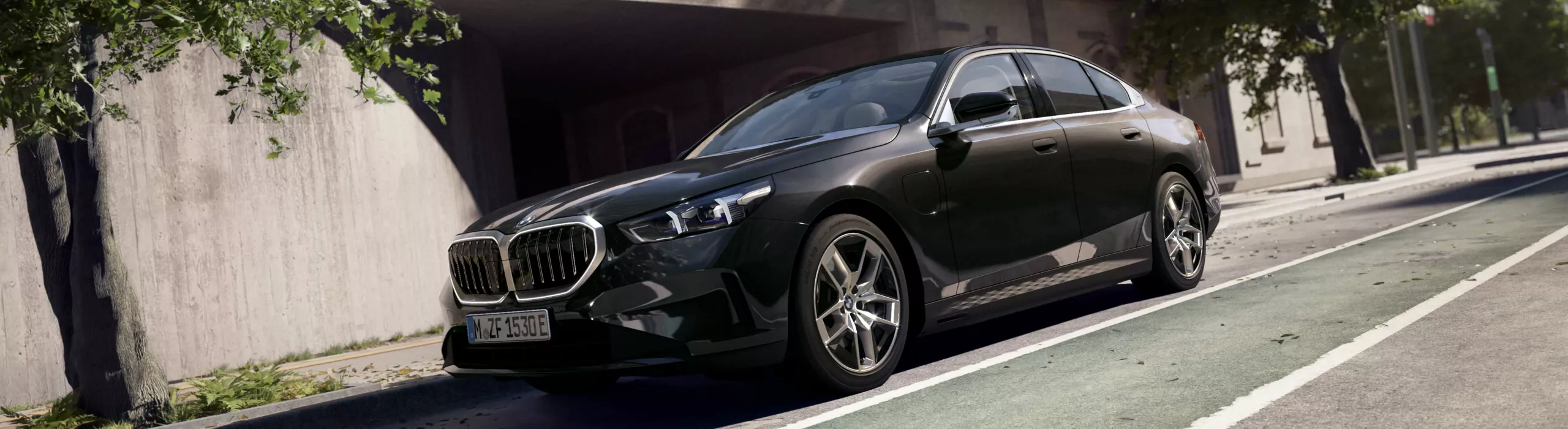 BMW sedan driving along a city street lined with modern architecture and greenery.