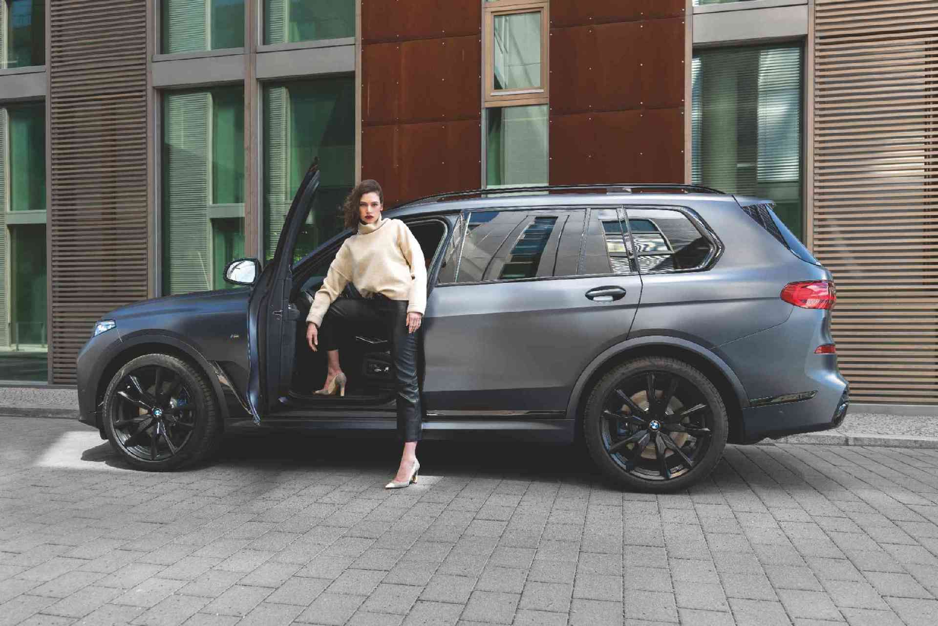 BMW Financial Services couple in front of BMW in a building