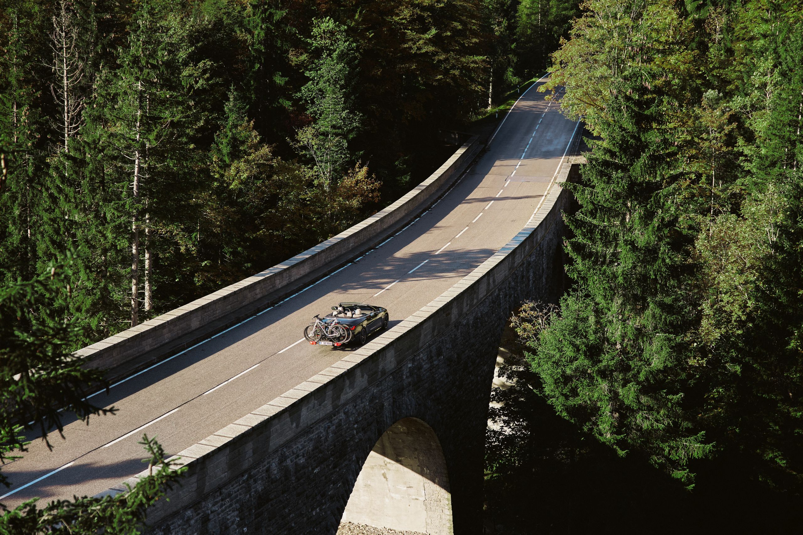  BMW 4 Series Convertible a circular na estrada no meio da natureza