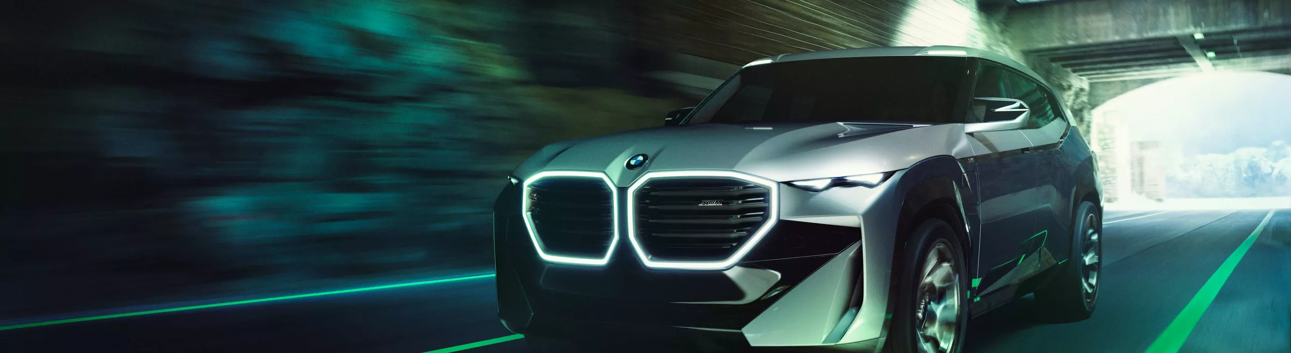 Futuristic BMW SUV with illuminated kidney grille driving through a tunnel at high speed
