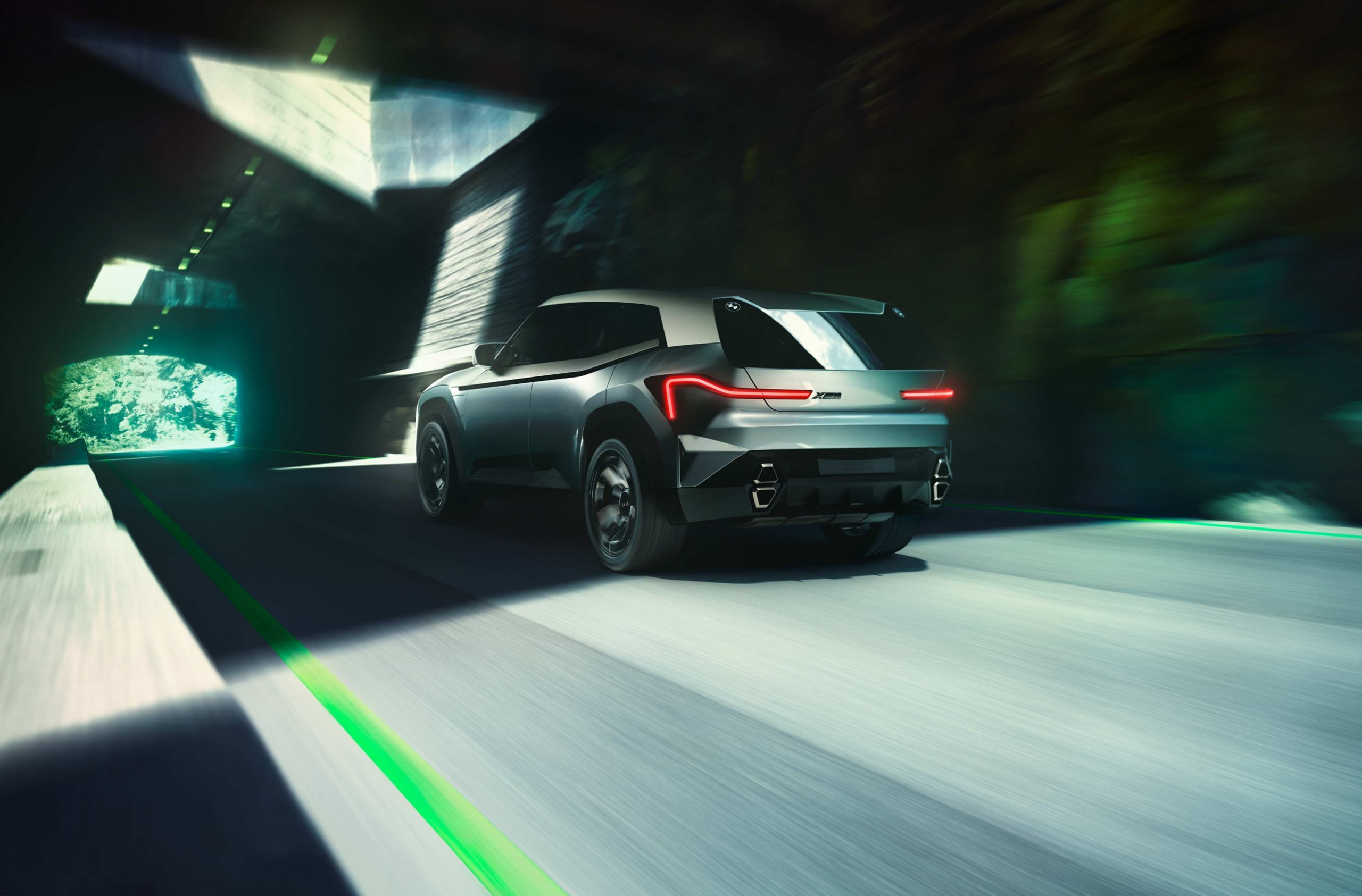 Rear view of futuristic BMW concept SUV driving through a tunnel with sleek LED taillights and aerodynamic design